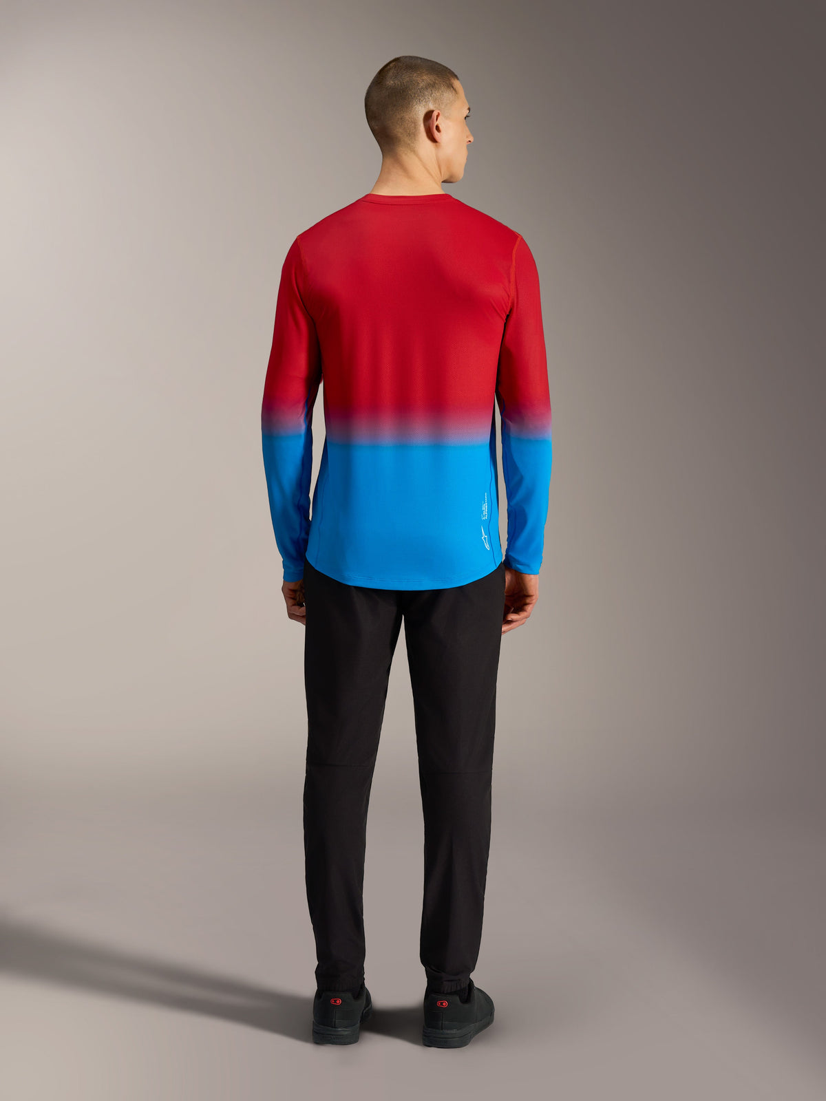Maillot VTT Alpinestars A-Dura ASTARS 2.0, manches longues avec dégradé rouge et bleu, vue de dos sur modèle.