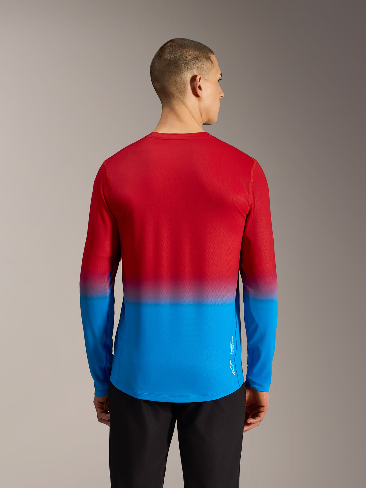 Maillot VTT Alpinestars A-Dura ASTARS 2.0, dégradé rouge et bleu, manches longues et pan arrière allongé.