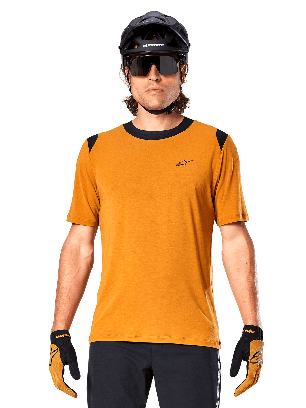 Maillot à manches courtes Alpinestars A-Dura Dri Wool, Or foncé, porté avec un casque de VTT noir, des lunettes de soleil et des gants, doté d'un col et d'empiècements aux épaules noirs, mélange de laine drirelease respirant pour le VTT