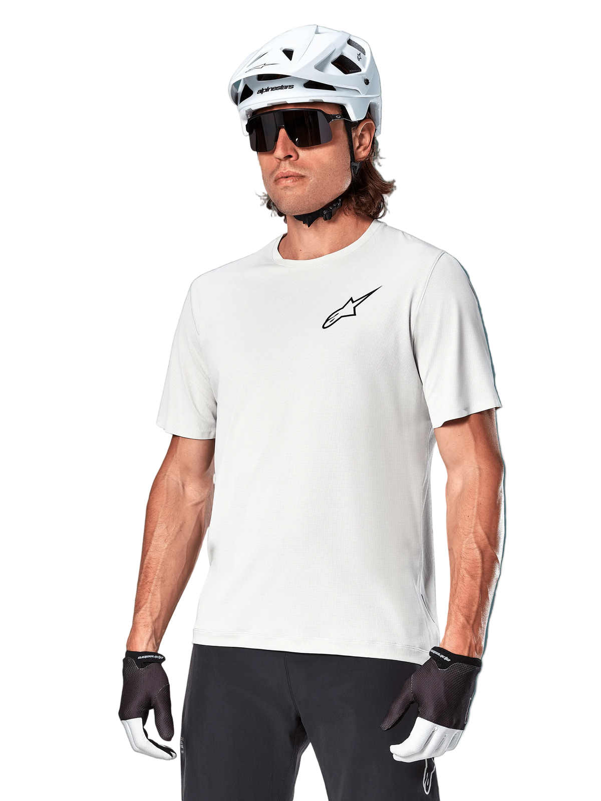 Maillot à manches courtes Alpinestars A-Aria Astar, White Dove, porté par un cycliste avec un casque blanc et des lunettes de soleil foncées, arborant un petit logo d'étoile noir sur la poitrine, équipement de performance respirant pour le VTT