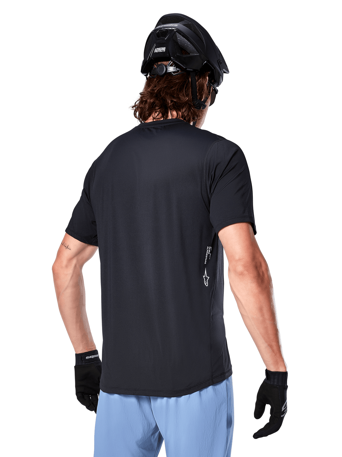 Alpinestars A-Dura Oscar Jersey, maillot de cyclisme à manches courtes, noir, vue de dos sur un cycliste, associé à un short bleu clair et un casque VTT noir, petit logo blanc sur le côté, vêtement de performance pour le VTT
