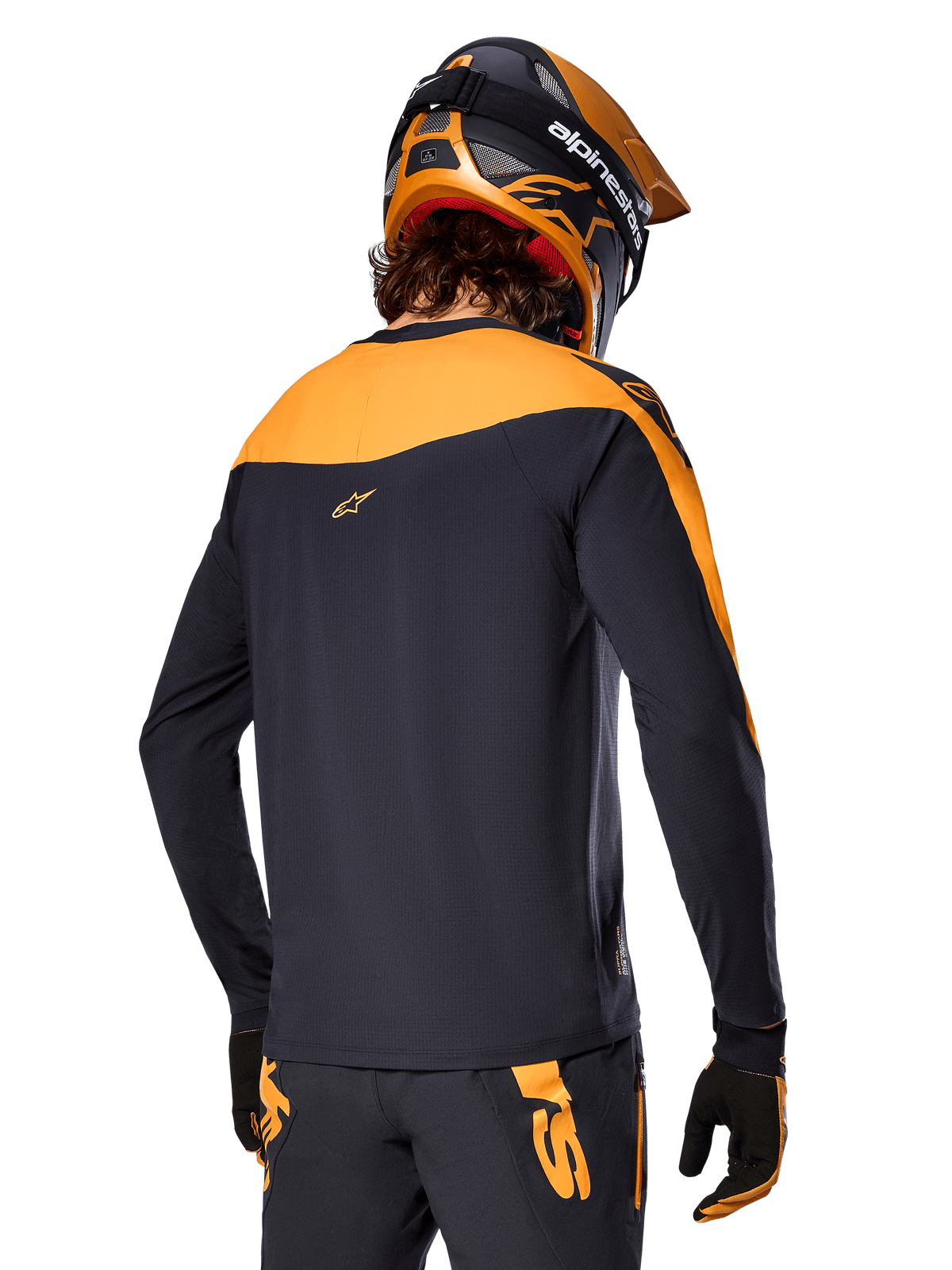 Alpinestars A-Supra Race Jersey - Long Sleeve, Black and Orange, back view of rider wearing matching helmet and mountain bike pants, performance fit with micro-perforated texture, professional MTB racing gear