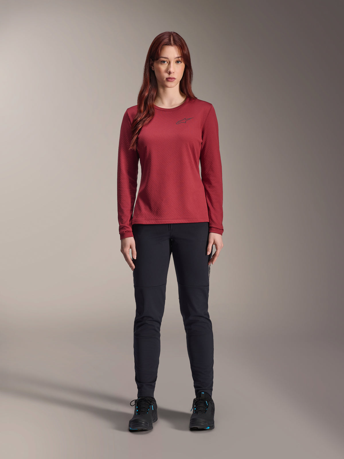 Maillot thermique Alpinestars Stella A-Dura pour femme, maillot de cyclisme à manches longues, bordeaux, porté par un mannequin avec un pantalon noir et des chaussures noires, logo discret sur la poitrine, coupe régulière pour le VTT