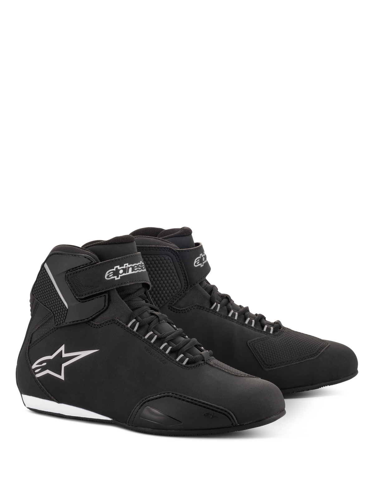 Chaussures de moto imperméables Alpinestars Stella Sektor pour femme, noir et argent, tige élégante en microfibre avec fermeture à lacets et sangle velcro à la cheville, logo étoile Alpinestars argenté sur le côté et semelle fine en caoutchouc.