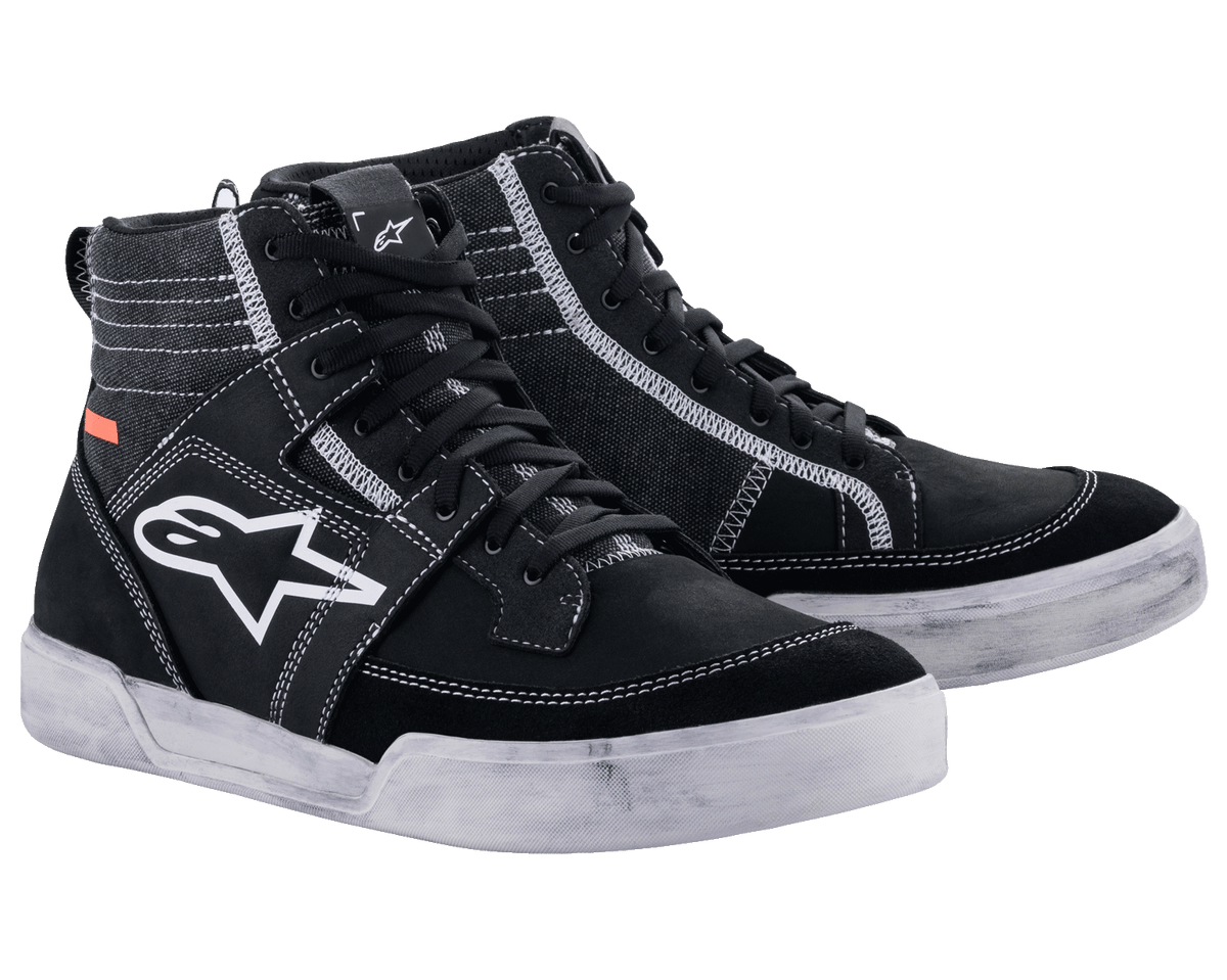 Chaussures Alpinestars Ageless Riding Shoes, chaussures de moto urbaines, noir avec surpiqûres et semelles blanches contrastées, silhouette de baskets montantes avec un grand logo étoile blanc sur le côté, équipement de protection décontracté pour la conduite sur route