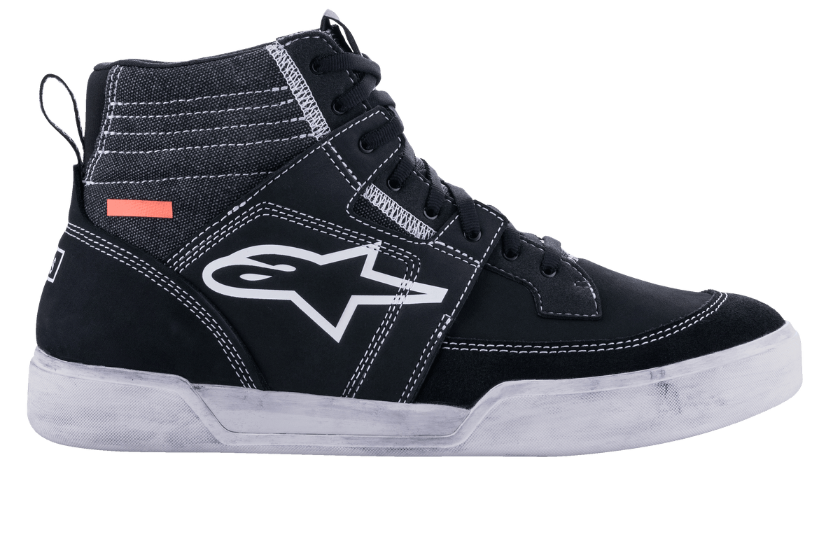Chaussures de conduite Alpinestars Ageless, chaussures de moto urbaines, noir et blanc, silhouette de basket montante avec empiècements en daim et toile, surpiqûres blanches contrastées, logo A-star blanc sur le côté et semelle en caoutchouc blanc