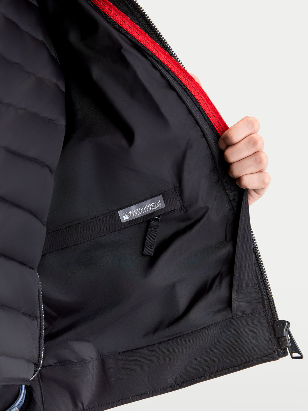 Alpinestars Revern Veste en cuir, blouson de moto urbain pour homme, détail intérieur montrant la doublure de gilet thermique amovible, le compartiment de rangement étanche et l'accent zippé rouge, noir