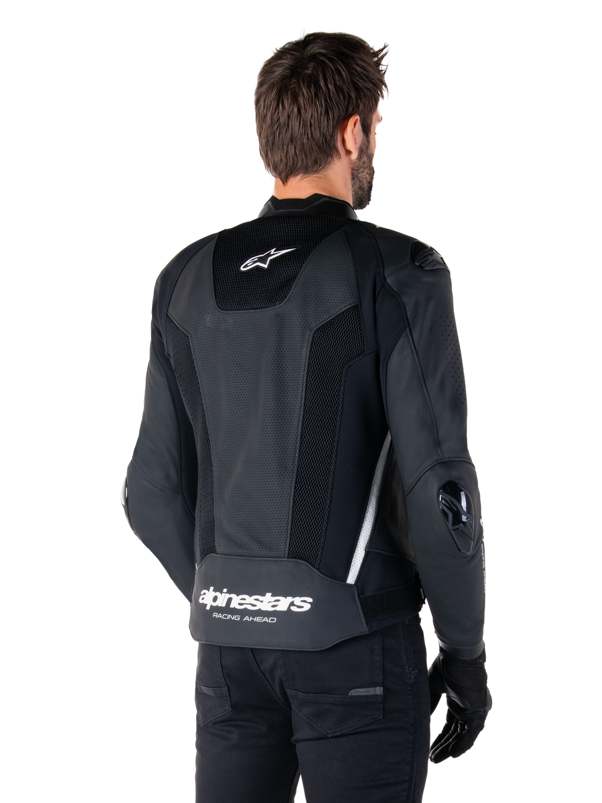 Veste en cuir Alpinestars Missile V3 Airflow, noir et blanc, vue arrière avec cuir perforé et panneaux en mesh pour une ventilation maximale, logo Alpinestars blanc sur le bas du dos et logo étoile sur le col, portée avec un équipement de moto noir, design sportif haut de gamme.