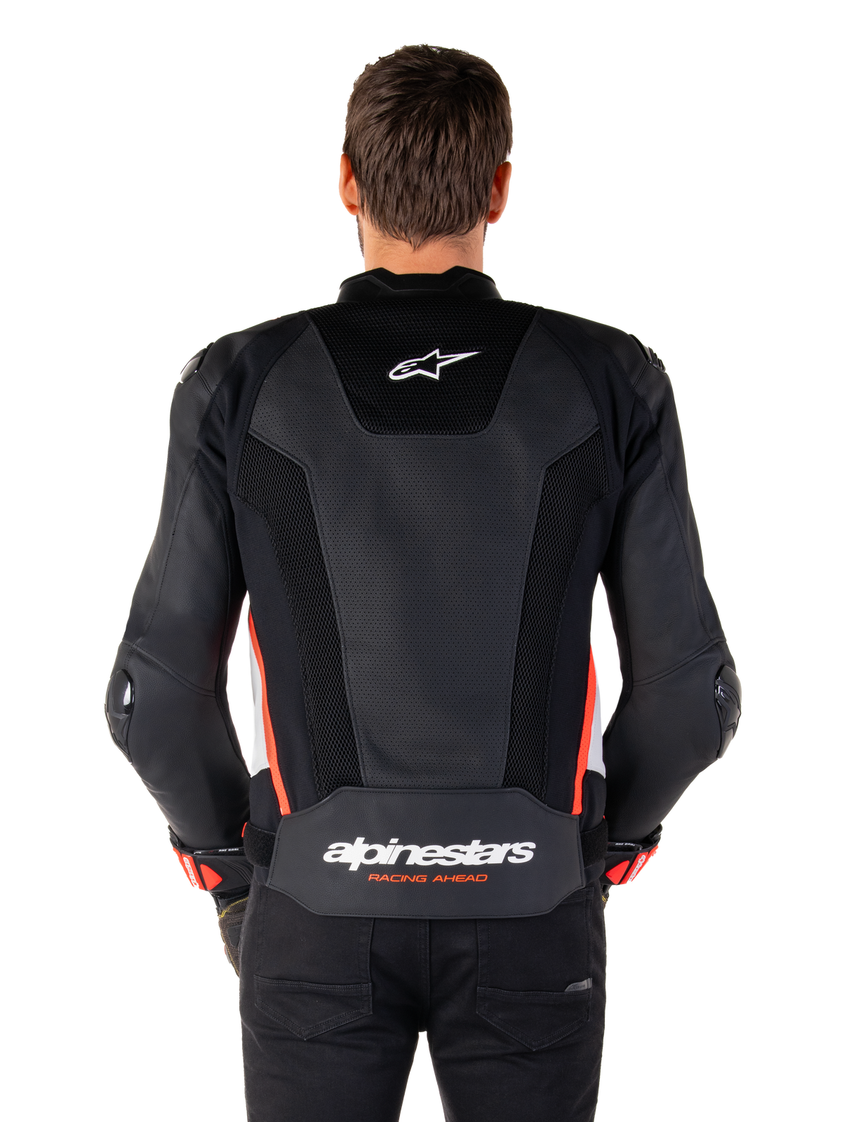 Vue arrière d'une personne portant la veste en cuir Alpinestars Missile V3 Airflow en Noir Blanc Rouge Fluo, dotée de larges panneaux en cuir perforé pour la ventilation, d'un petit logo Alpinestars sur le haut du dos et d'un marquage « alpinestars RACING AHEAD » imposant au bas de la taille.