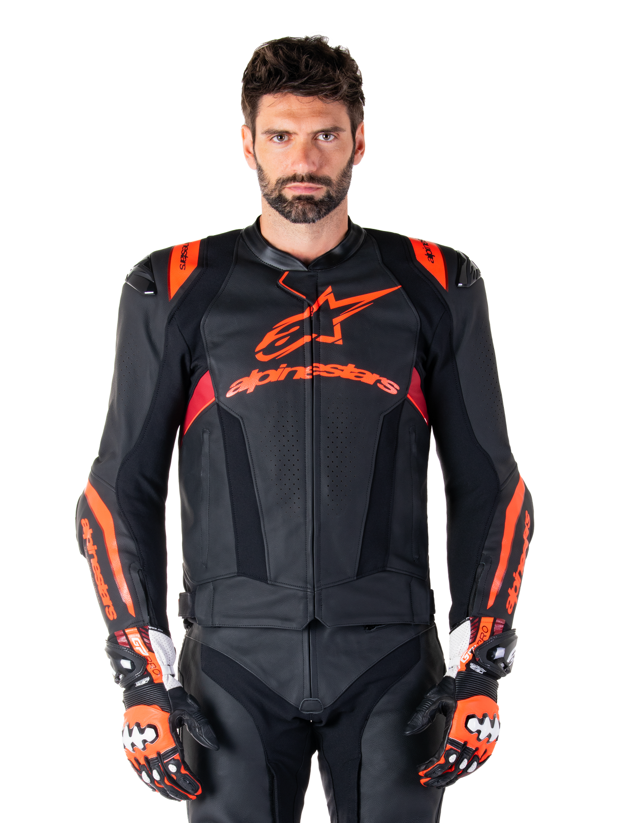 Veste en cuir Alpinestars Missile V3 Ignition, veste de moto de course, noir et rouge fluo, portée avec des gants de course et un pantalon en cuir assortis, avec zones de ventilation perforées et marquage Alpinestars bien visible, équipement de course professionnel