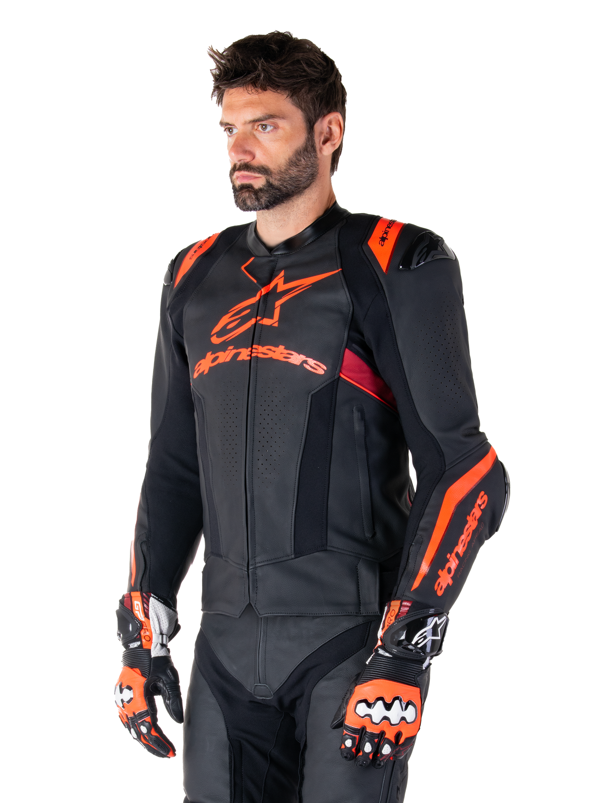 Veste en cuir Alpinestars Missile V3 Ignition, noir avec accents rouge fluo et rouge foncé, portée par un mannequin homme avec gants de course et pantalon en cuir assortis, logo Alpinestars, panneaux en cuir perforé et protections d'épaules externes, équipement de course de moto professionnel
