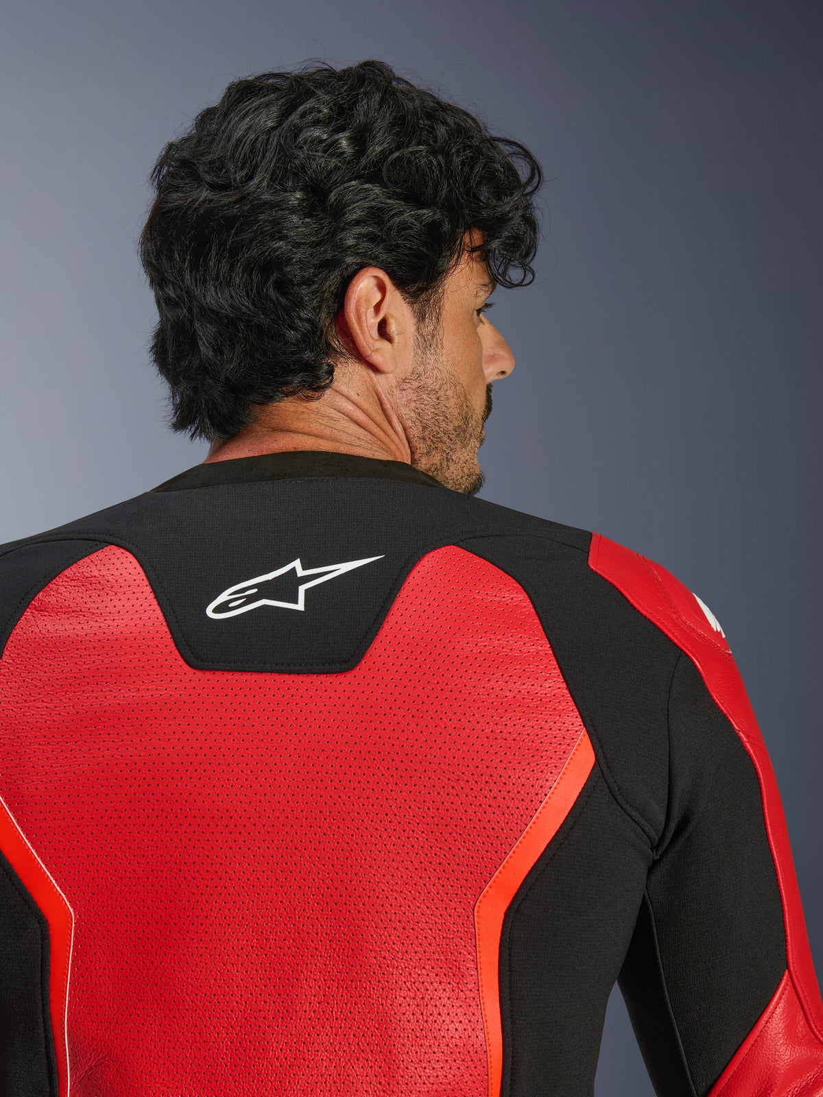 Blouson en cuir Alpinestars GP Force V2 Air, rouge et noir, vue arrière en gros plan montrant le cuir perforé pour une ventilation optimale, empiècement stretch noir avec logo Astars blanc, blouson de moto coupe sport