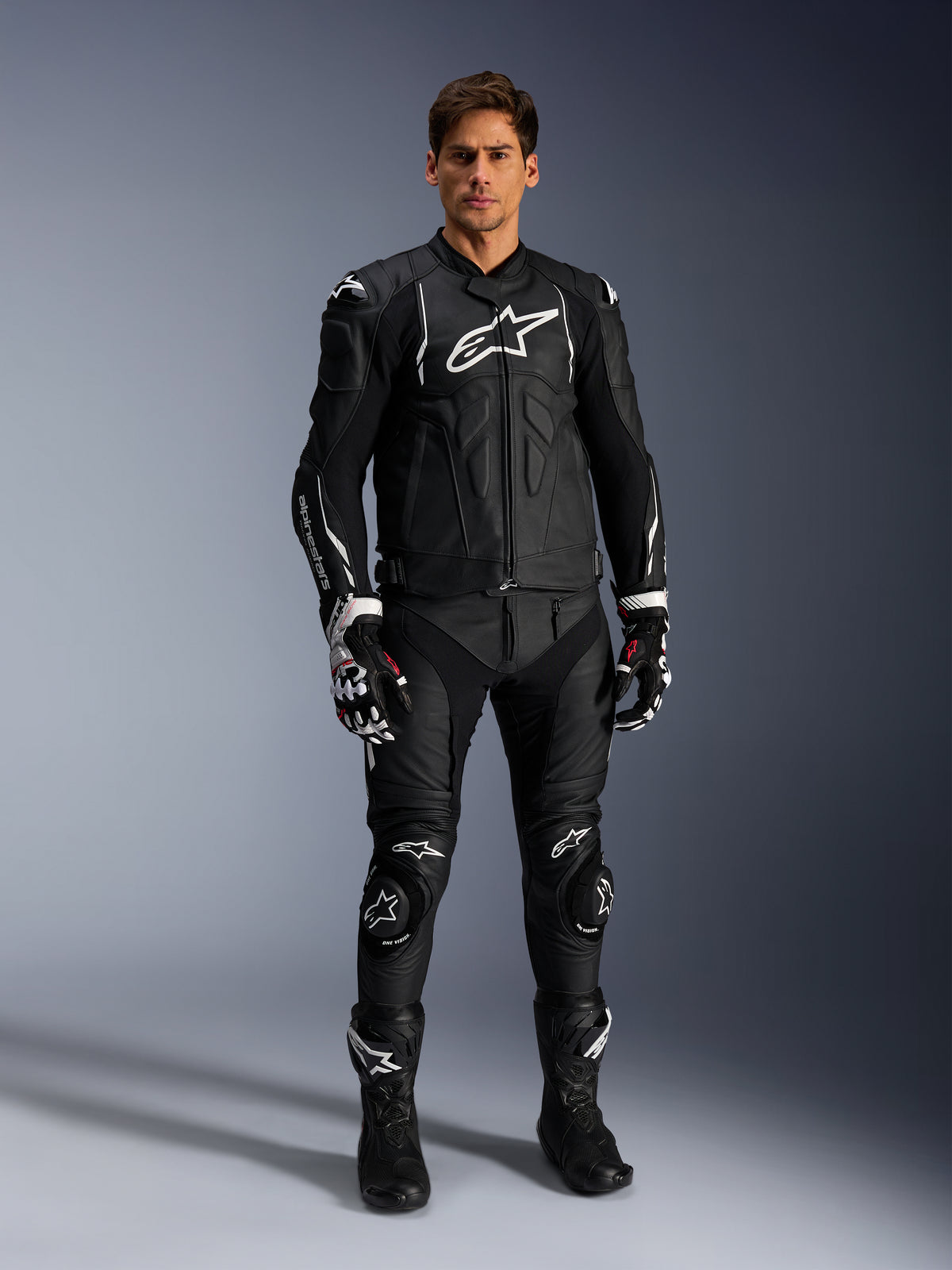 Veste en cuir Dusk Alpinestars, veste de moto sport pour homme, noire et blanche, cuir bovin, portée par un mannequin.