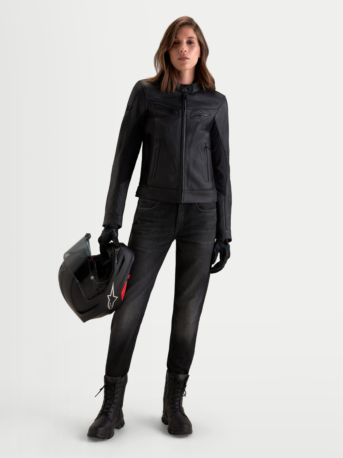 Alpinestars Stella Maver X Veste en cuir, blouson de moto urbain pour femme noir, vue de face d'un modèle portant la veste en cuir et tenant un casque, avec une construction en cuir souple