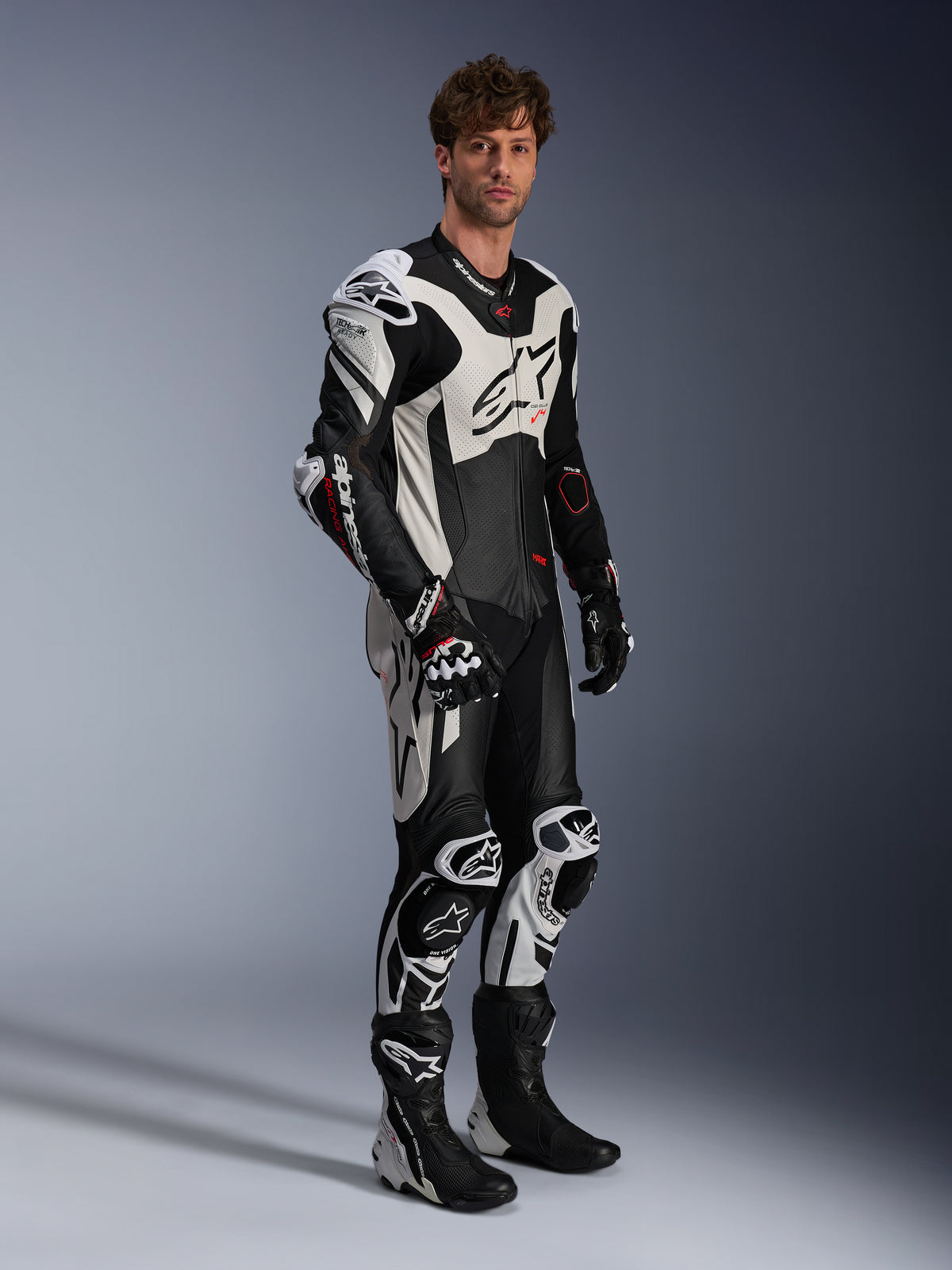 Alpinestars GP Plus V4 Sprint, combinaison en cuir 1 pièce pour homme, noire, blanche et rouge fluo, Tech-Air Ready, portée par un mannequin avec bosse aérodynamique.