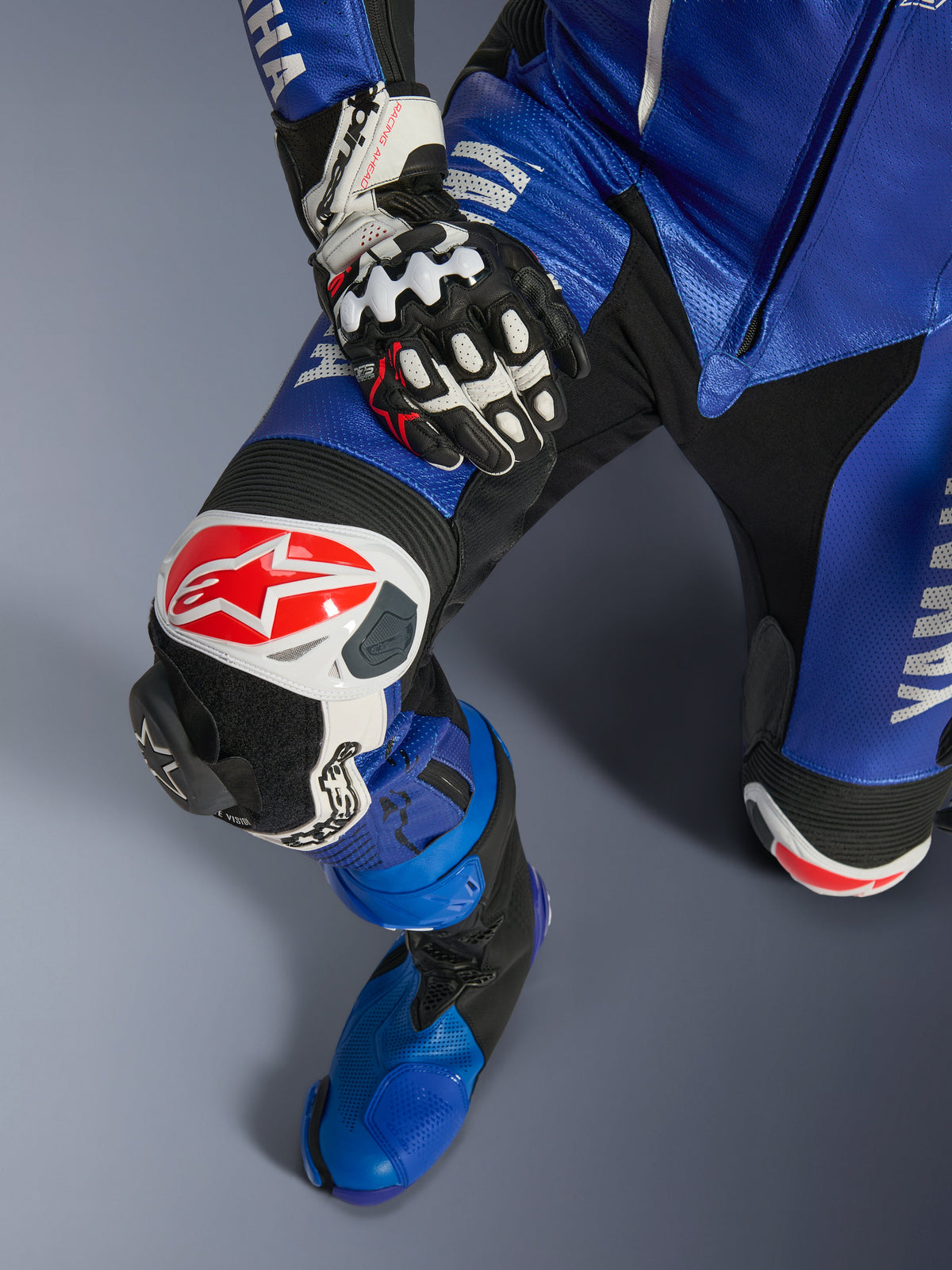 Combinaison en cuir une pièce Alpinestars Yamaha GP-R7, combinaison de moto, bleu métallisé et noir, avec logo Alpinestars blanc et rouge sur la protection du genou, slider de genou GP remplaçable et botte de course bleue assortie, équipement professionnel prêt pour la piste