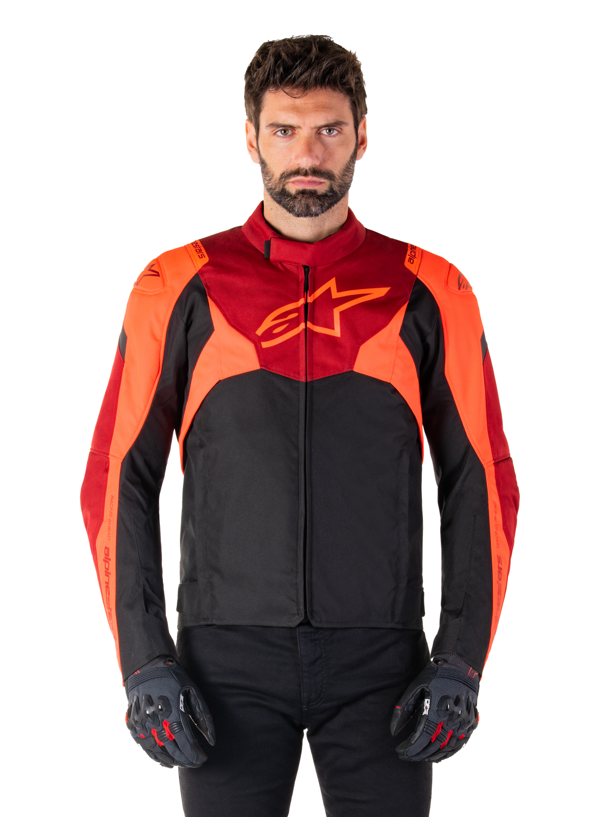 Alpinestars T-Jaws V4 Waterproof Jacket, veste de moto sport en textile, noir avec accents rouge fluo et rouge foncé, portée par un mannequin homme avec gants assortis, équipement de pilotage technique avec logo étoile proéminent sur la poitrine