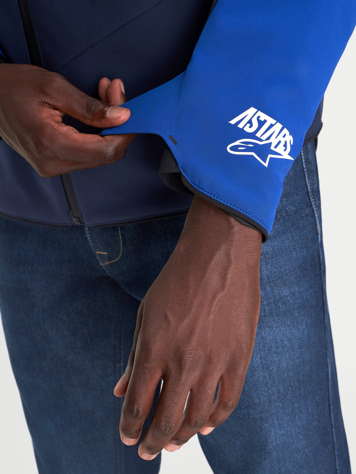 Alpinestars Aeroshell Wp veste de moto pour homme, vue rapprochée du poignet de la manche avec logo A-stars, bleu vif et bleu marine