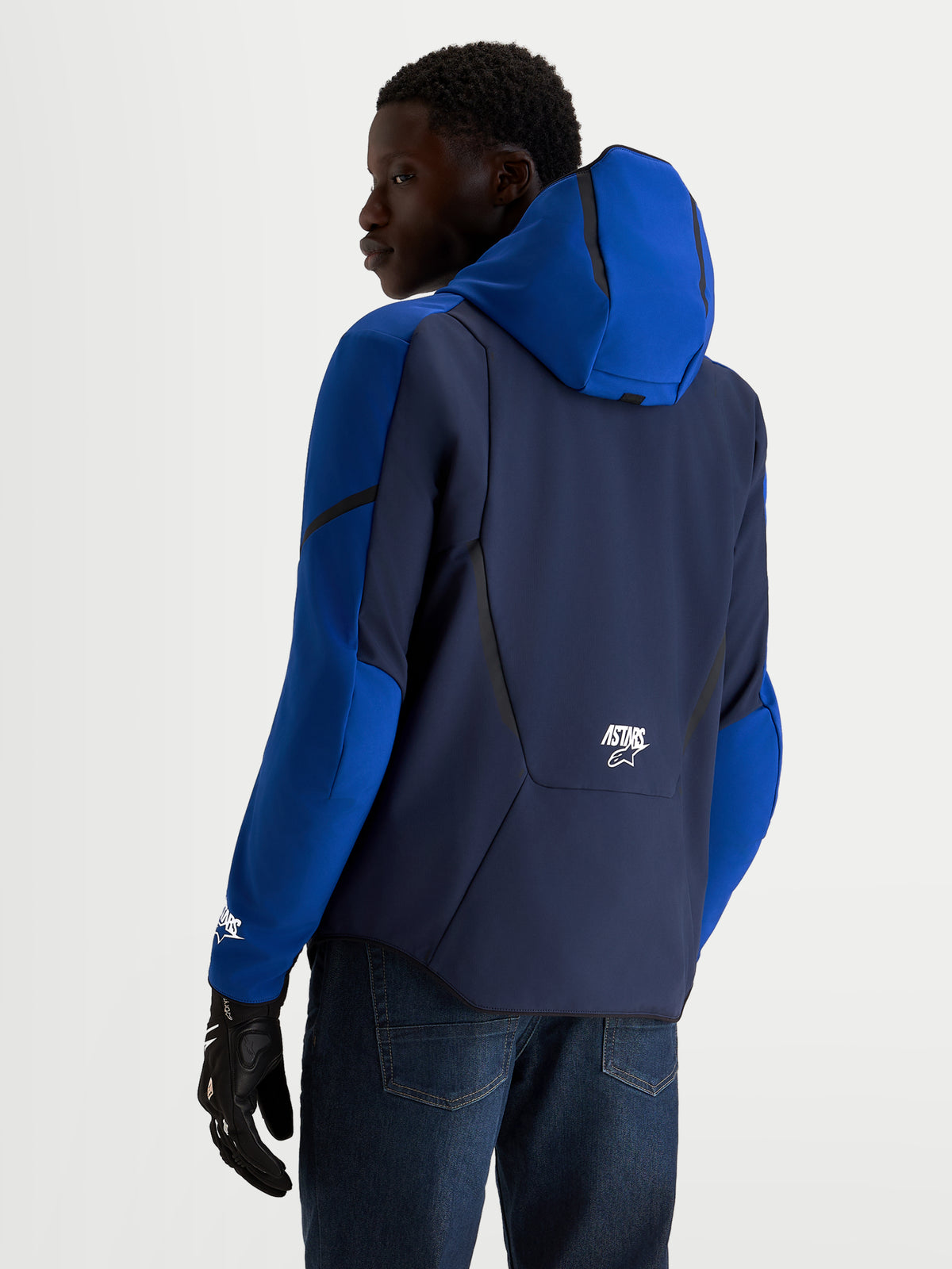 Alpinestars Veste Aeroshell Wp, veste de moto softshell imperméable pour homme bleu marine et bleu vif, vue de dos sur un modèle portant des gants de moto