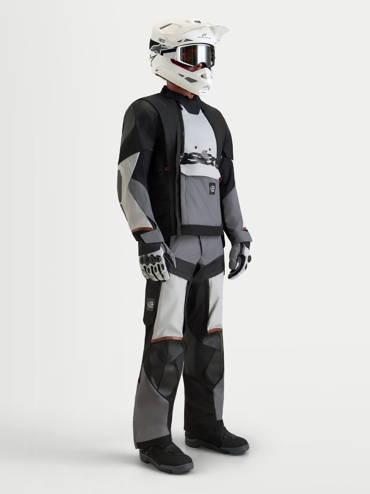 Alpinestars Harok V2 Drystar, veste de moto d'aventure pour homme grise, grise glacier et noire, portée avec un casque blanc et des gants de moto