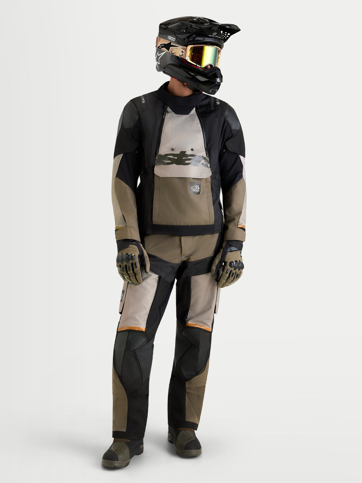 Alpinestars Harok V2 Drystar, tenue complète de moto adventure, noire et kaki, portée par un modèle portant un casque et des gants, avec une construction textile imperméable