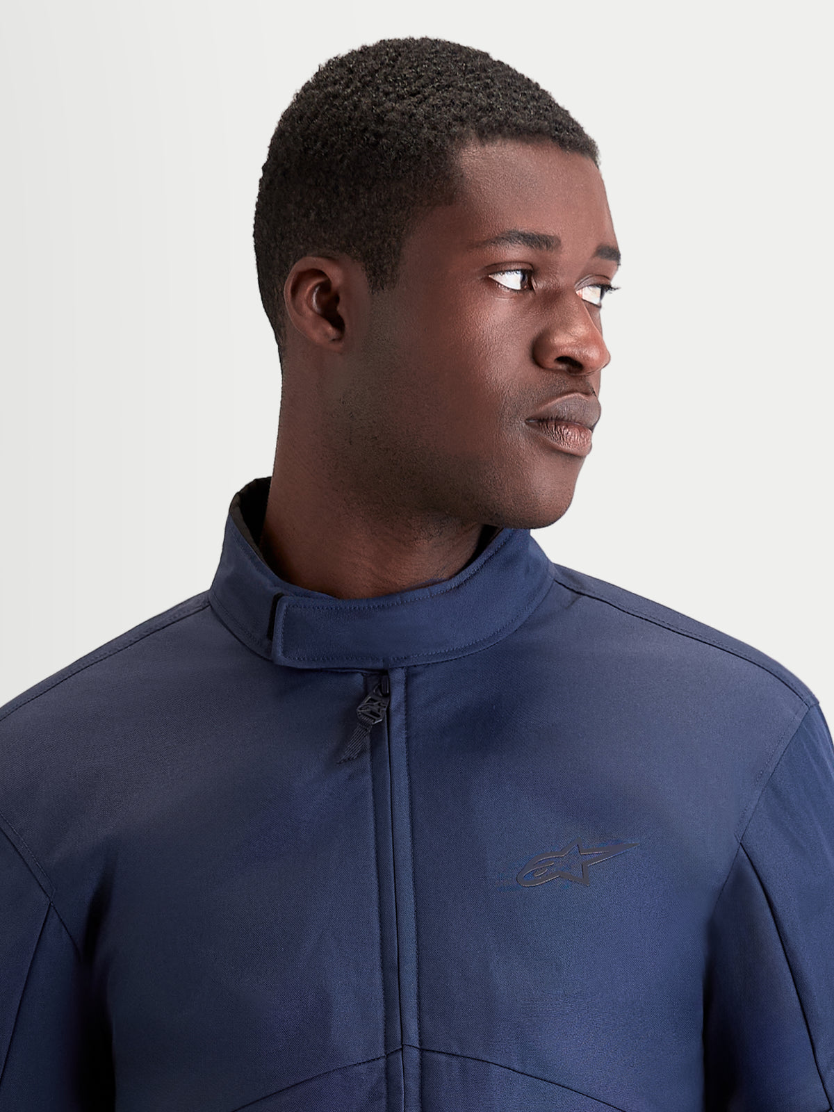 Alpinestars Veste C 1 Waterproof, veste de moto urbaine contemporaine en textile bleu foncé, vue en gros plan montrant le col ergonomique et la construction imperméable portée par un modèle