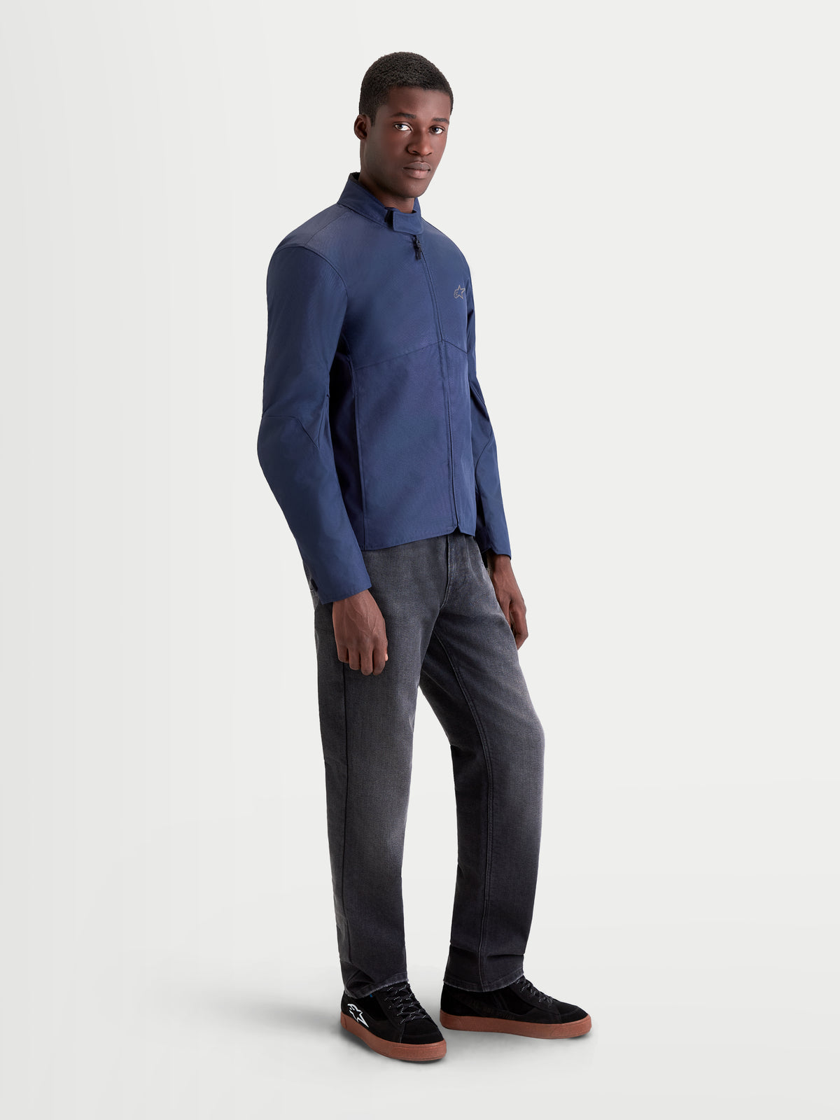 Alpinestars C 1 Waterproof Veste, veste de moto urbaine contemporaine pour homme en bleu foncé, vue de profil sur un modèle portant un pantalon foncé et des chaussures de moto
