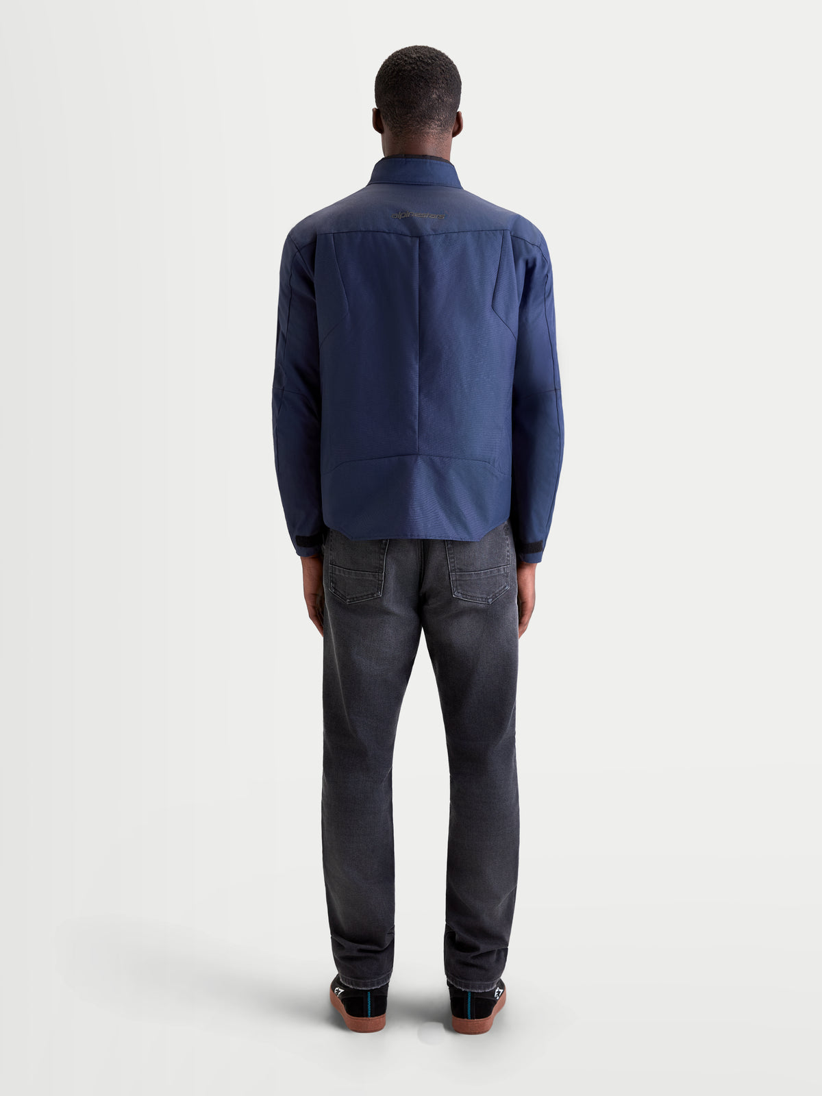 Alpinestars C-1 Waterproof Veste, veste de moto urbaine et contemporaine pour homme en bleu foncé, vue de dos montrant la construction ergonomique et le motif dorsal sur un modèle