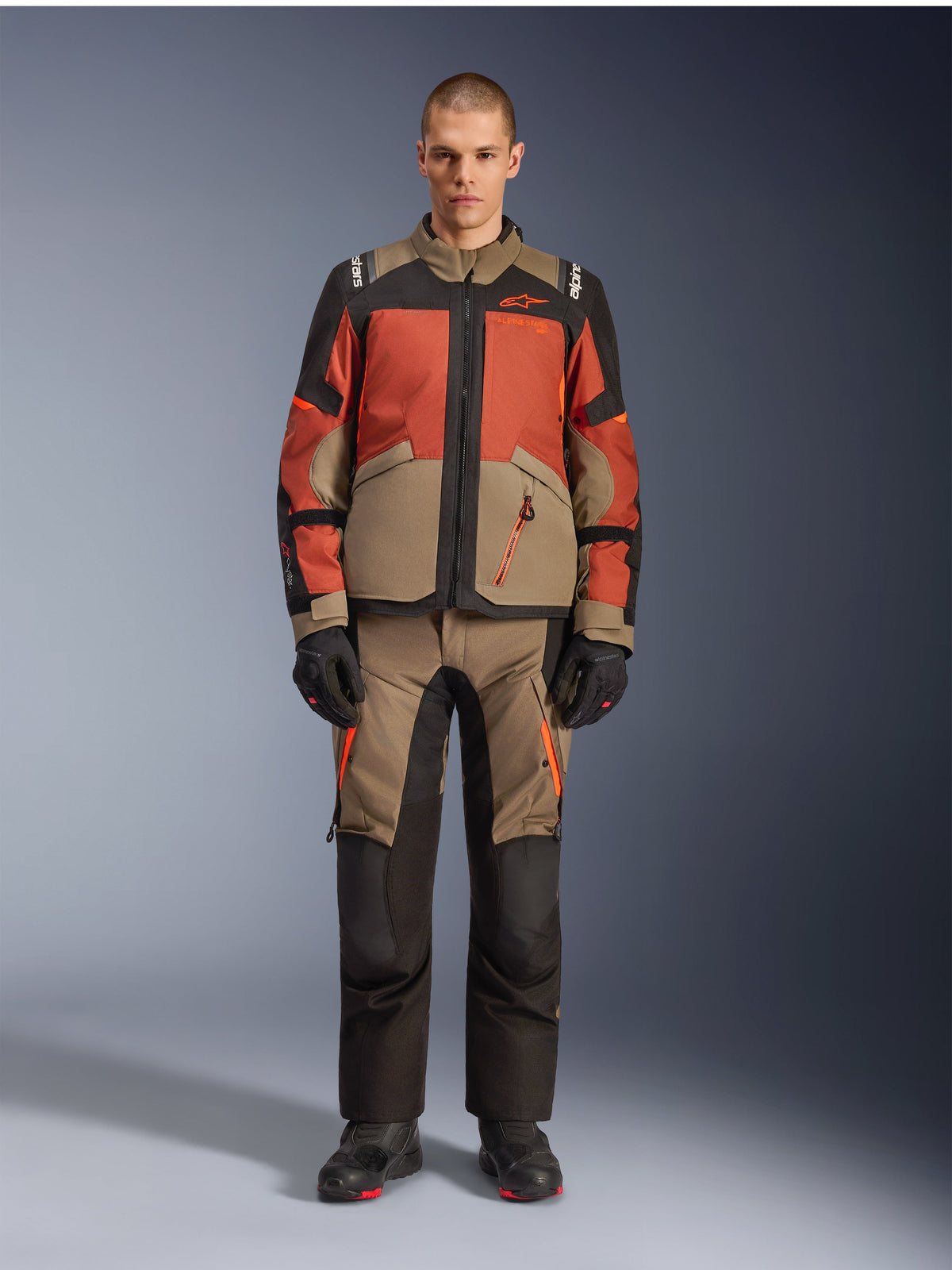Veste Alpinestars Andes V4 Drystar®, veste de moto d'aventure, Walnut Rust Black, portée avec un pantalon et des gants assortis, design multicolore avec des panneaux orange rouille et brun noyer, équipement textile durable pour la conduite tout-terrain