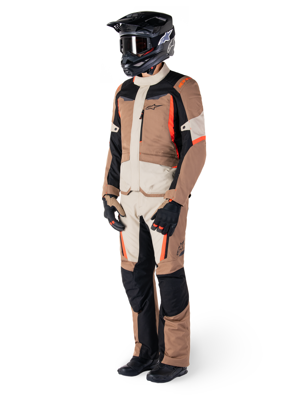 Alpinestars ST-1 Waterproof Jacket, Dark Khaki Sand Black Red Fluo, worn by a rider in full adventure touring gear with matching pants, black helmet, goggles, gloves, and boots, technical all-weather motorcycle outfit