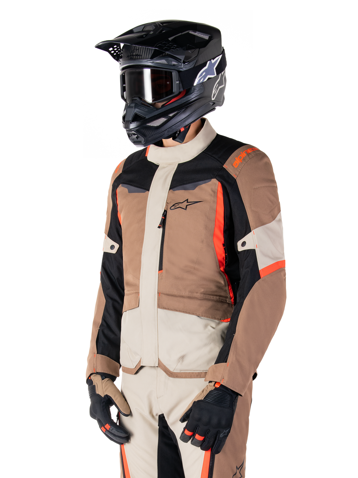 Alpinestars ST-1 Waterproof Jacket, Adventure Touring Jacket, Dark Khaki Sand Black and Red Fluo, worn by a rider with a black motocross helmet and goggles, featuring a multi-panel design with cargo pockets and Alpinestars branding on the chest
