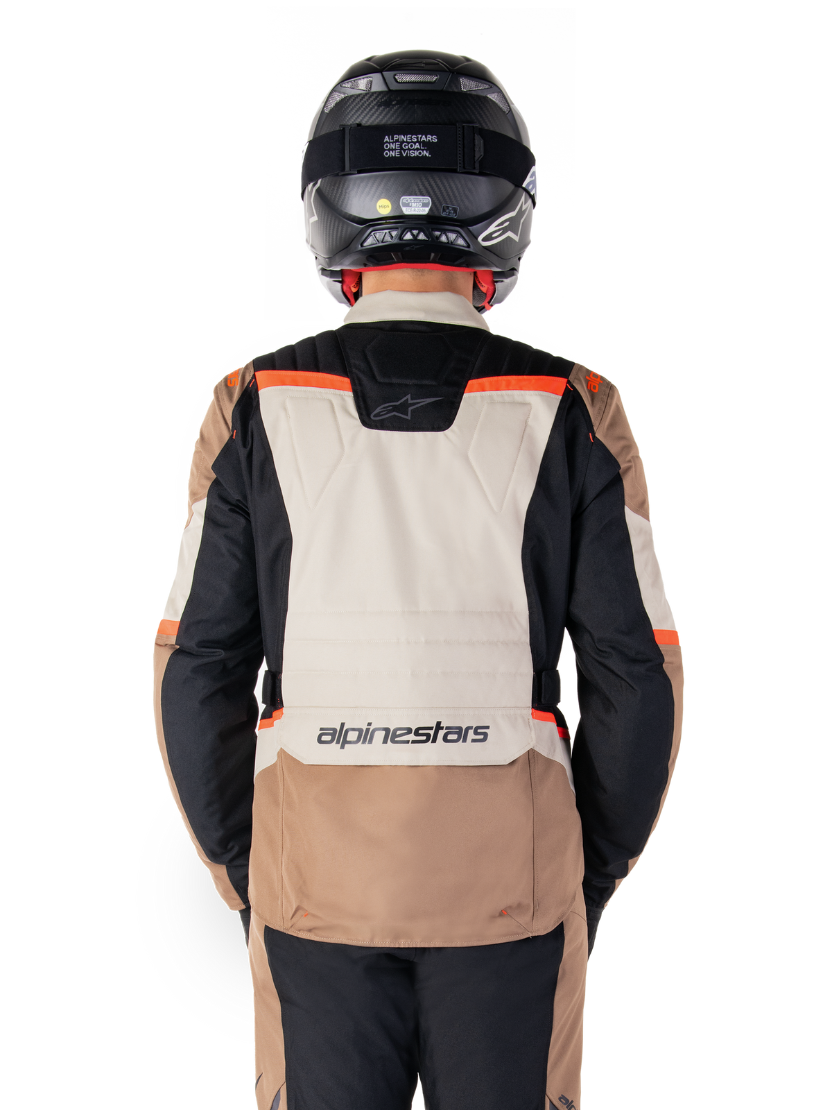 Alpinestars ST-1 Waterproof Jacket, Dark Khaki Sand Black Red Fluo, Rear view, adventure touring motorcycle jacket featuring a large sand-colored back panel, black sleeves, and red fluorescent accents, shown on a rider with a black helmet.
