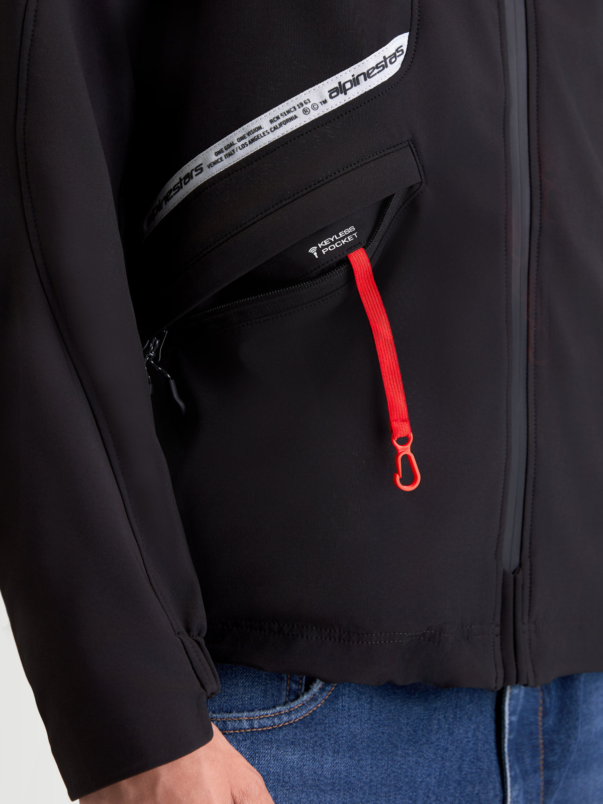 Alpinestars C-5 Drystar Jacket, men's urban motorcycle textile jacket, black, close-up view of the keyless pocket with a red zipper pull and branded chest graphic
