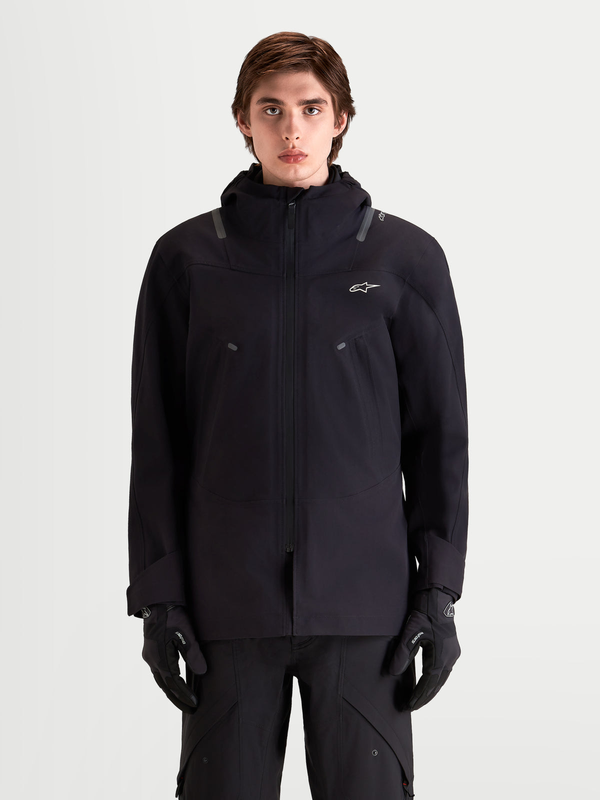 Alpinestars C 7 Drystar Xf Veste, veste de moto urbaine contemporaine en textile pour homme noire, vue de face sur un modèle portant des gants assortis et une capuche intégrée, design imperméable et respirant