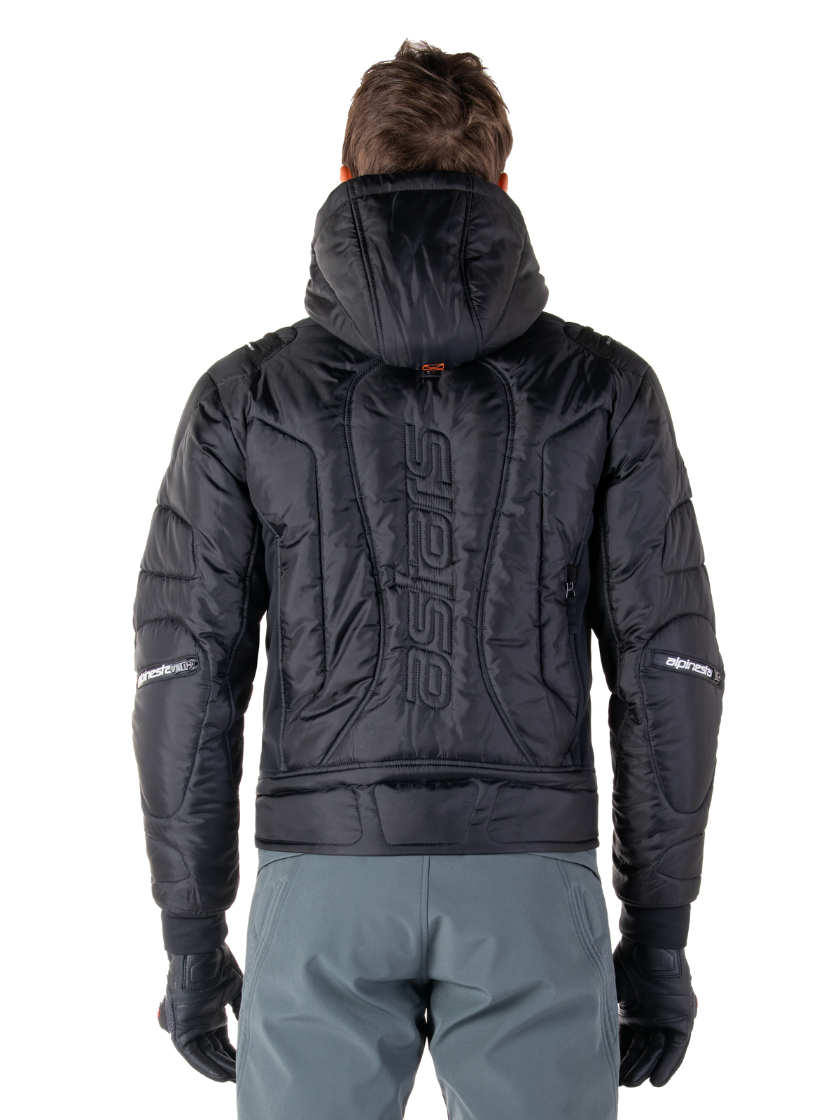 Veste Alpinestars Mohobbs Waterproof, noire, vue de dos montrant la construction matelassée rembourrée, mot-symbole 'astars' vertical au dos, capuche relevée, style moto streetwear contemporain