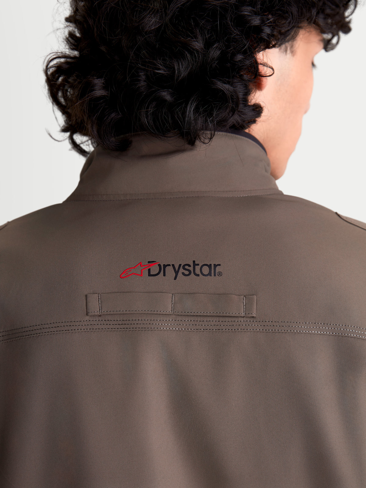 Alpinestars Altan Drystar Veste, veste moto urbaine contemporaine imperméable pour homme en marron et noir, vue rapprochée de dos montrant le col chaud intégré, le marquage Drystar au dos et la construction en polyfabric durable