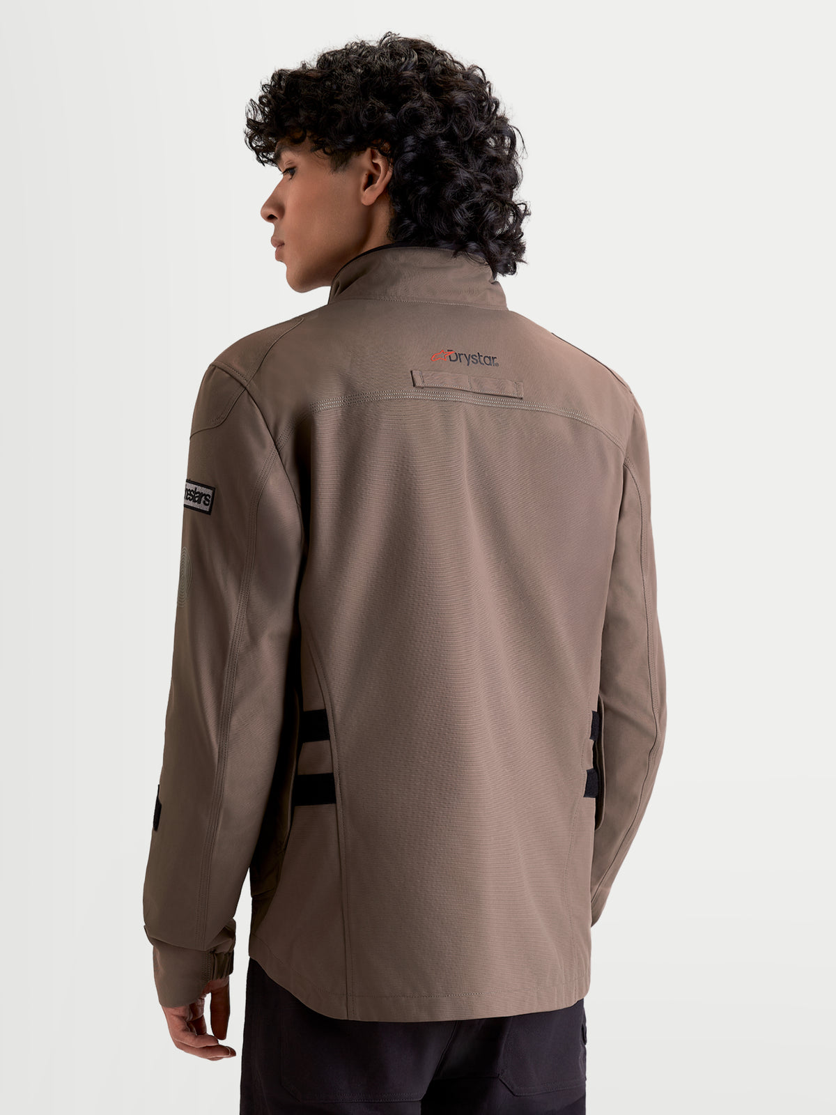 Alpinestars Altan Drystar Veste, veste de moto urbaine contemporaine et imperméable pour homme marron et noire, vue de dos sur un modèle montrant la silhouette de type veste de travail et le marquage Drystar