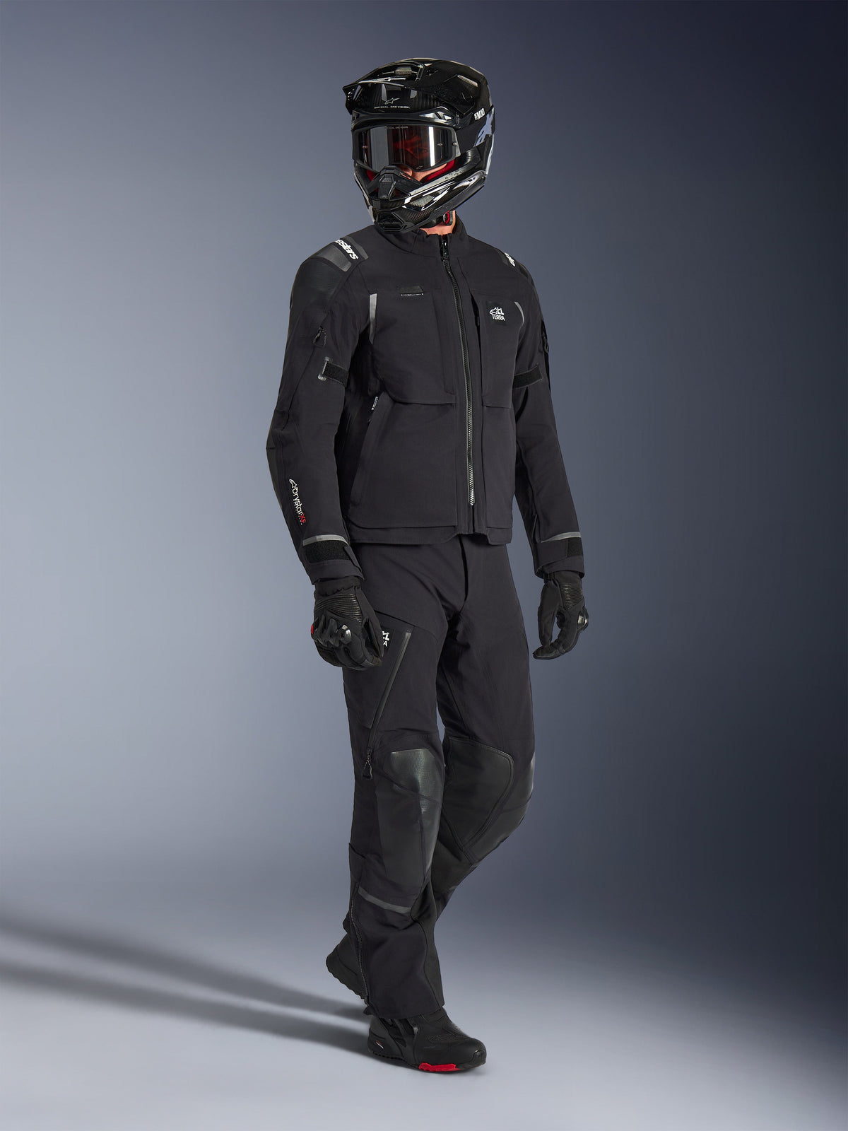 Alpinestars Andes Pro Drystar® XF Jacket, Black and Dark Gray adventure motorcycle jacket, worn with matching black textile pants, black full-face helmet with goggles, gloves, and boots, featuring a laminated 3-layer shell and multiple storage pockets for all-season adventure riding.