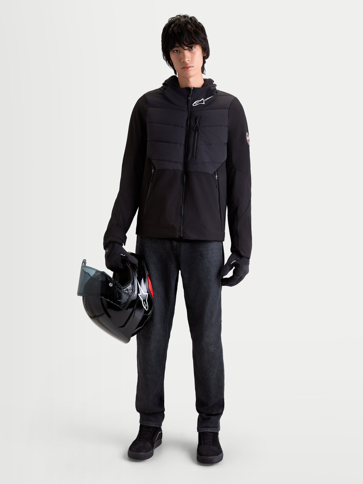Alpinestars Therma Tech WP Veste, veste de moto urbaine pour homme noire, vue de face sur un modèle portant des gants assortis et tenant un casque