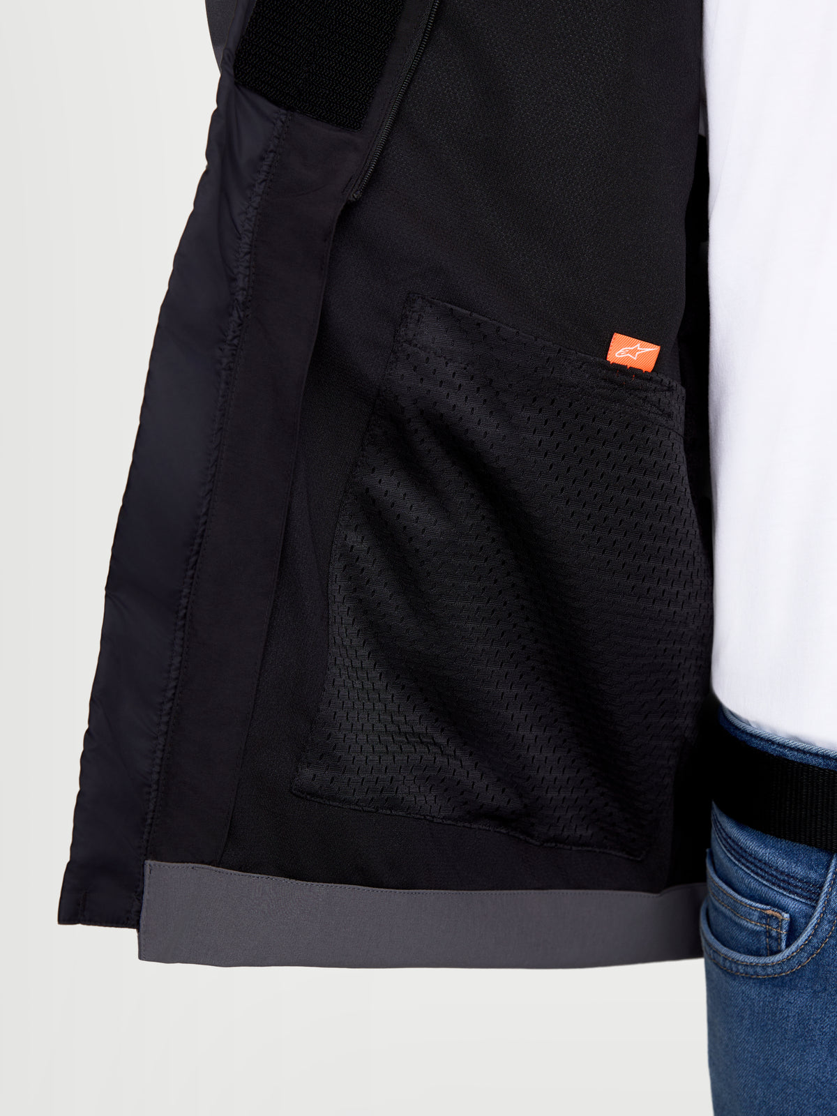 Alpinestars Therma-Tech Waterproof Jacket, urban motorcycle jacket, close-up interior view showing mesh pocket and brand logo detail, black and dark gray, softshell textile construction