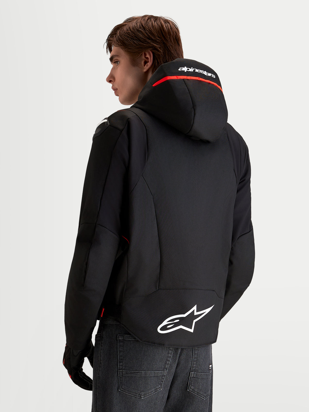 Veste Zaca V 2 Waterproof d'Alpinestars, veste de moto pour homme noire et rouge, avec capuche intégrée et logo blanc à l'arrière, vue de dos
