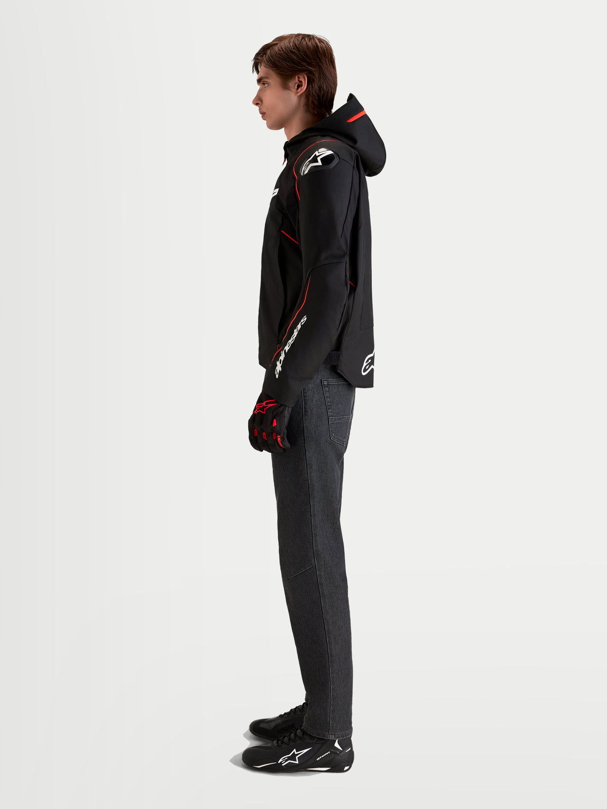 Alpinestars Veste Zaca V 2 Waterproof, veste de moto sport imperméable pour homme noire et rouge fluo avec capuche intégrée et protections d'épaules DFS, portée par un modèle de profil