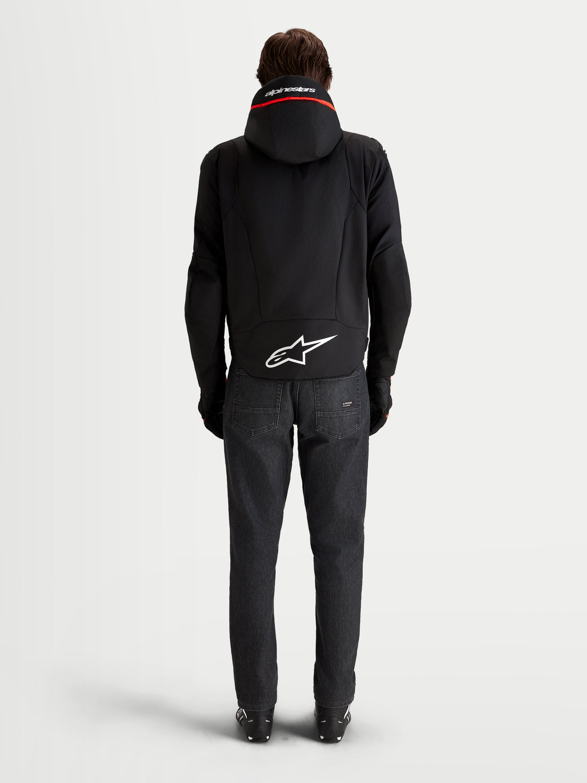 Alpinestars Zaca V2 Waterproof Veste, veste de moto imperméable pour homme, noire, vue de dos montrant la capuche intégrée et le logo Astar blanc sur l'ourlet