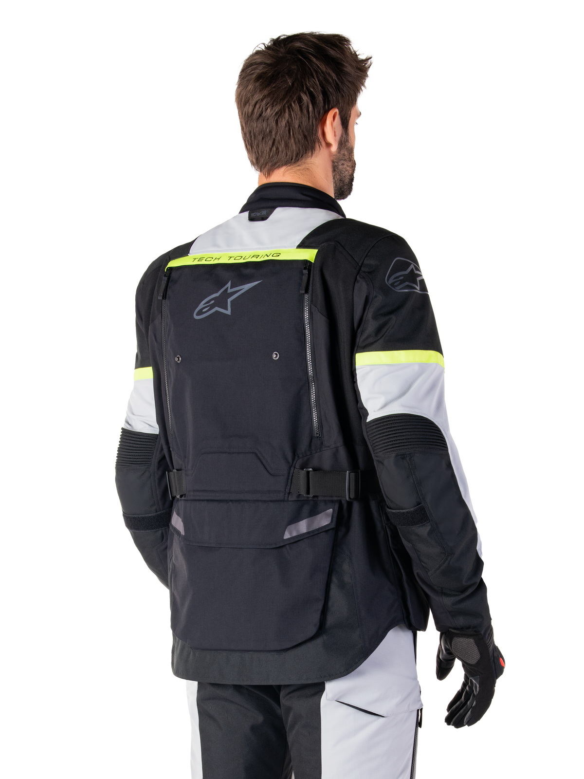 Veste Alpinestars Bogotá Pro Drystar®, veste de touring d'aventure, Noir, Gris Glace et Jaune Fluo, vue arrière montrant le grand panneau de poche arrière avec marquage 'TECH TOURING', logo Alpinestars et accents fluorescents, équipement moto technique en textile