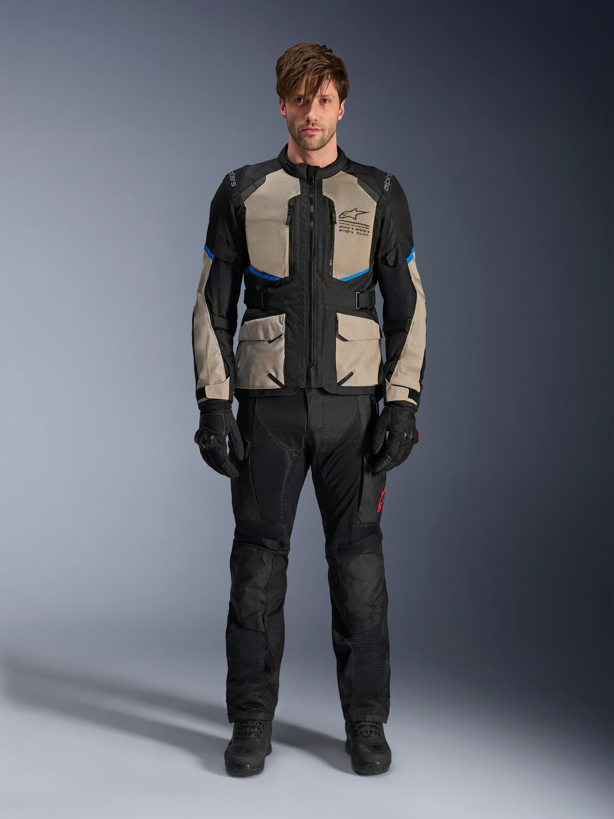 Model wearing Alpinestars Andes Air Drystar® Jacket, Motorcycle Touring Jacket, Black Laurel Gray and Bright Blue, paired with matching black riding pants and gloves, featuring extensive mesh ventilation panels on the chest and sleeves for warm-weather adventure touring.