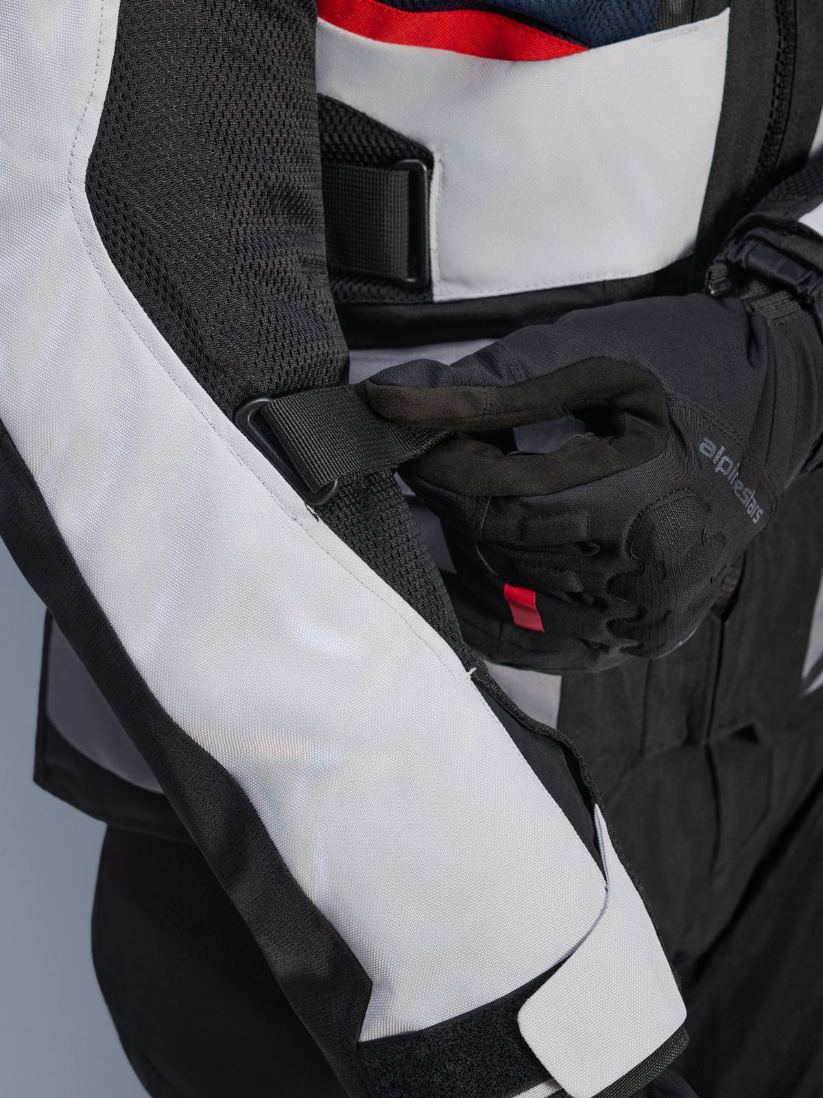 Veste Alpinestars Andes Air Drystar® bleu profond, noir et gris glacé, vue rapprochée de la sangle de manche réglable et des panneaux de ventilation en maille, construction textile durable pour le touring d'aventure