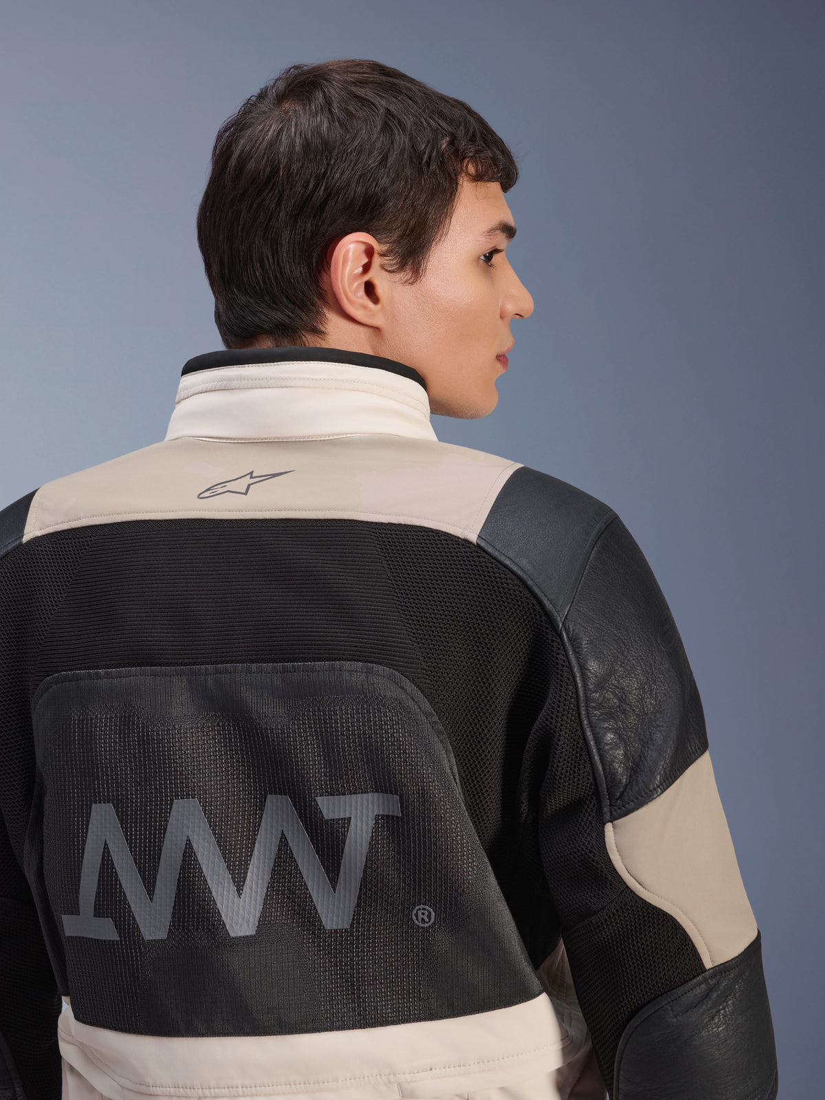 Veste Alpinestars AMT-10LAB Drystar® XF, vue de dos sur mannequin homme, coloris White Sand Aluminum Camo et noir, avec grand marquage AMT, panneaux de ventilation en mesh et renforts en cuir, vêtement technique de moto aventure