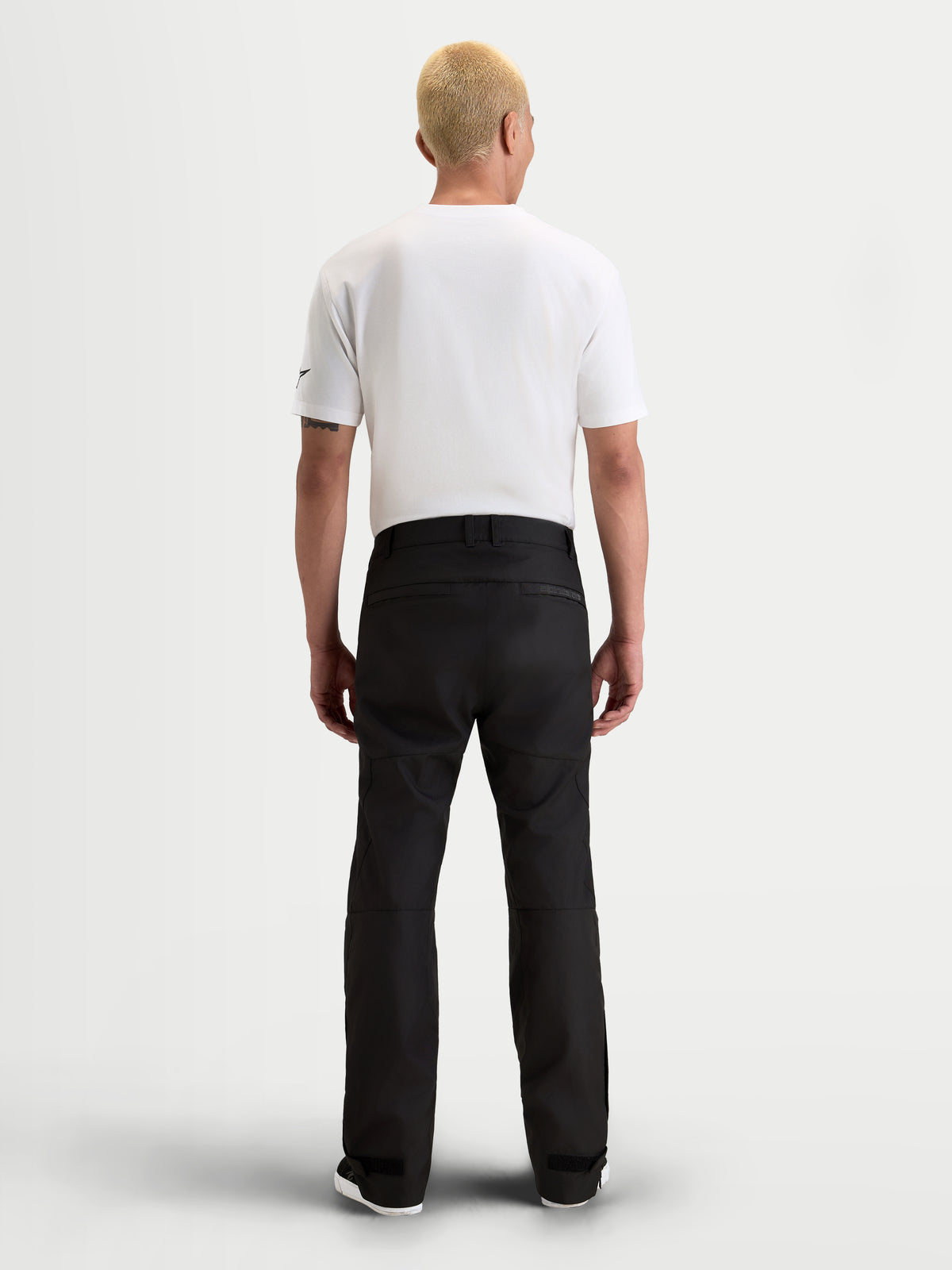 Alpinestars C 1 Waterproof Pantalons, pantalon de moto urbain pour homme noir, vue de dos sur un modèle portant un t-shirt blanc et un équipement textile imperméable