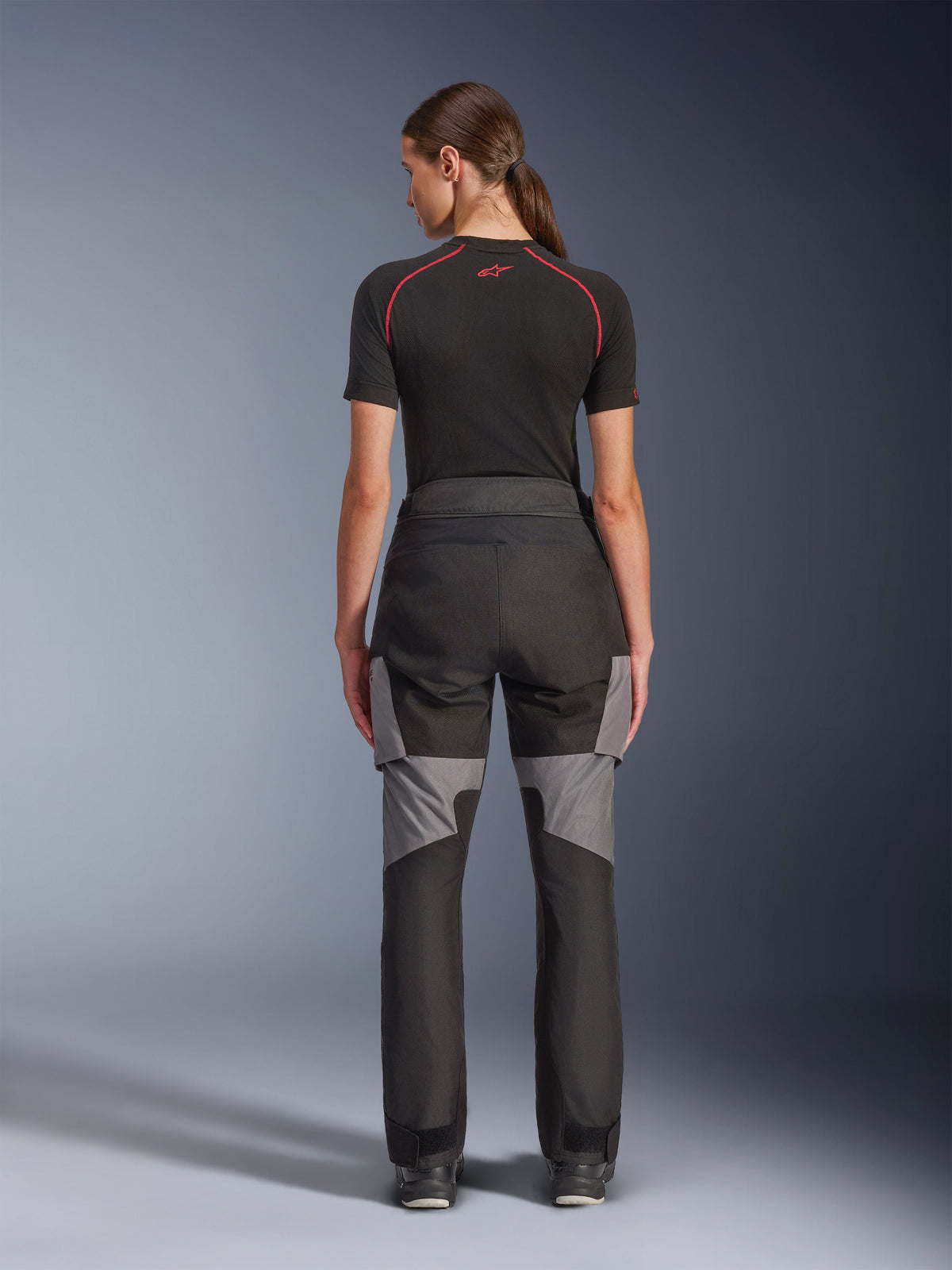 Pantalon Alpinestars Stella Andes V4 Drystar®, pantalon de moto pour femme, noir et gris foncé, vue de dos montrant les renforts en ripstop gris et le design ergonomique, porté avec une couche de base technique noire, équipement de moto adventure touring