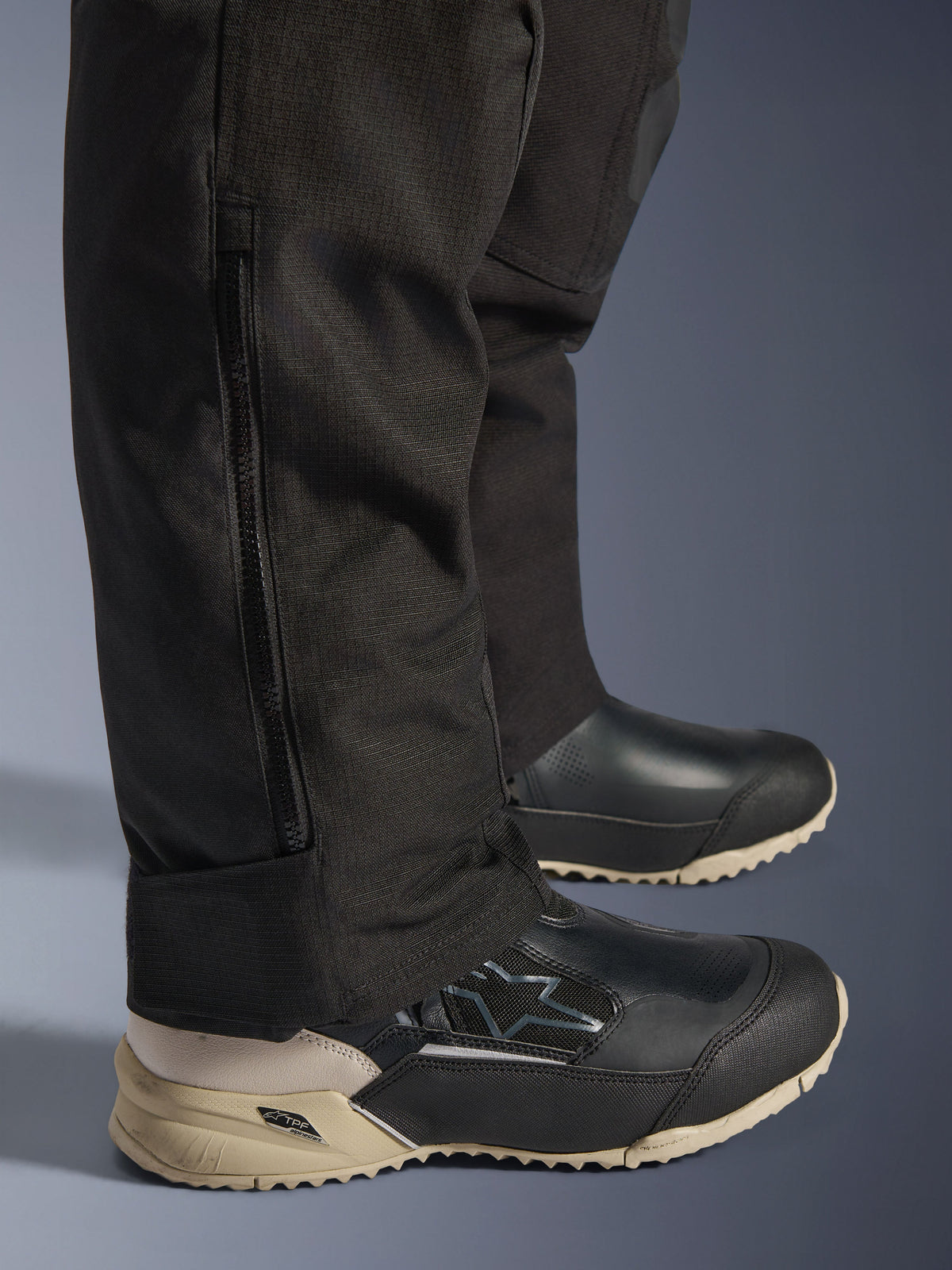 Pantalon Alpinestars Stella Andes V4 Drystar®, détail du bas de la jambe noir montrant une fermeture éclair latérale verticale pour l'ajustement des bottes, construction en tissu textile durable, équipement de moto d'aventure pour femme